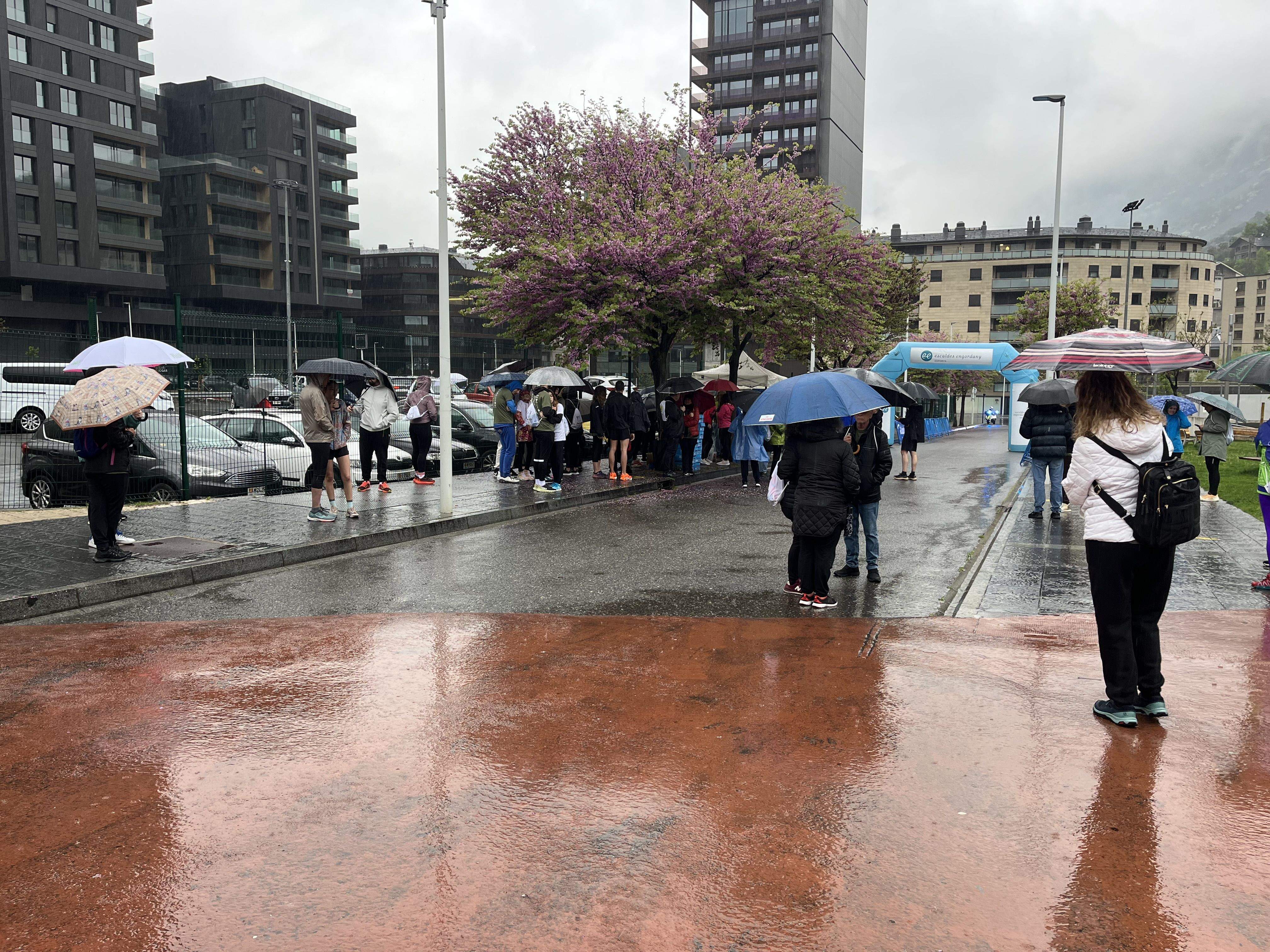 Els primers en arribar esperant sota la pluja. 