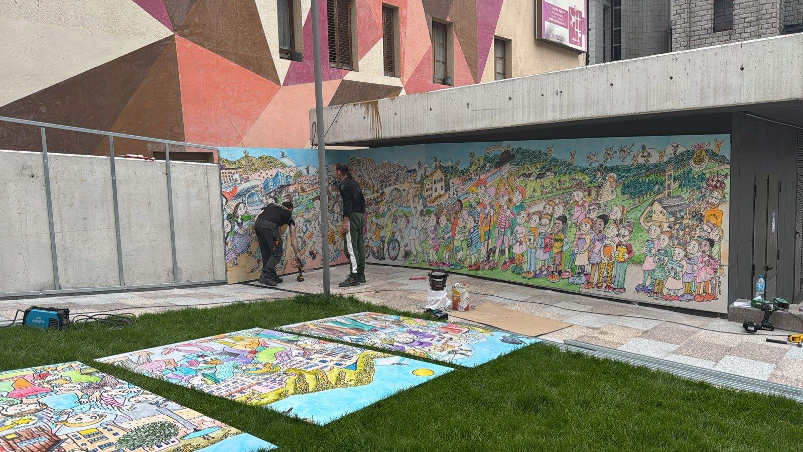Instal·lació del mural de Pilarín Bayés que recull referències als espais més emblemàtics, les tradicions i la identitat de la parròquia.