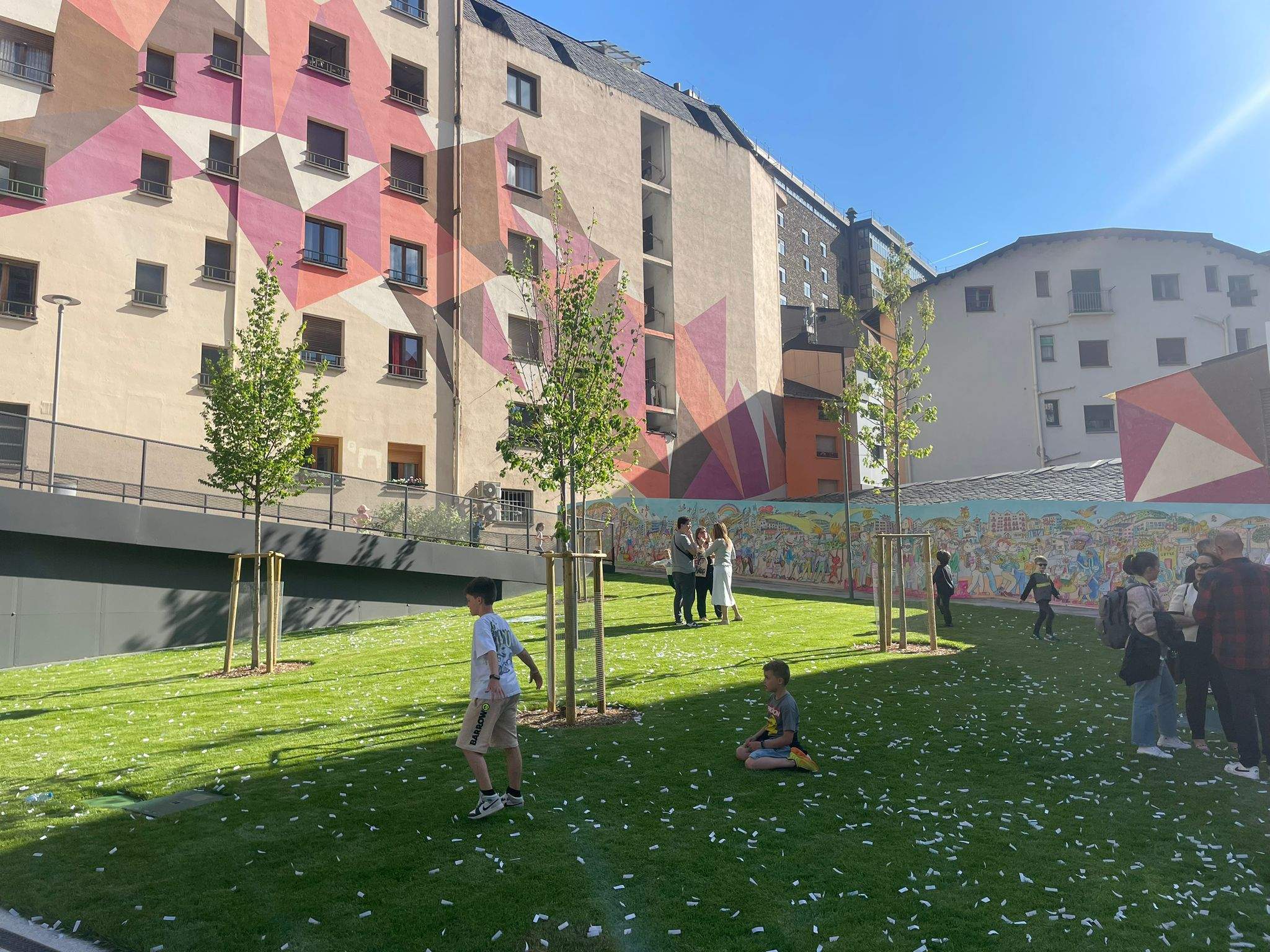 Zona de verda de la nova plaça de l’Església amb el mural de Pilarín Bayés al fons.