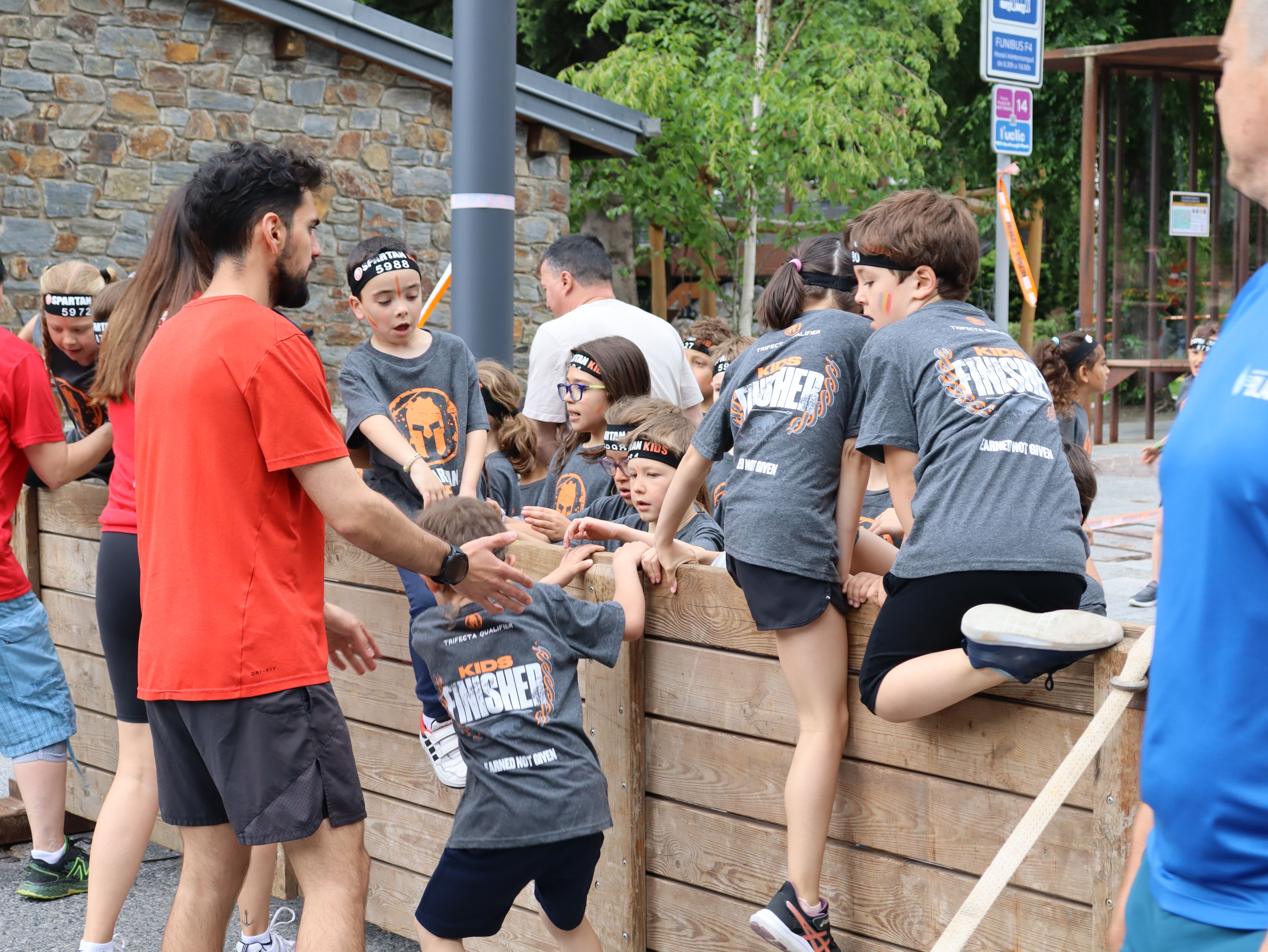 Diversos nens saltant una tanca a l'itinerari. Diversos nens saltant una tanca a l'itinerari.