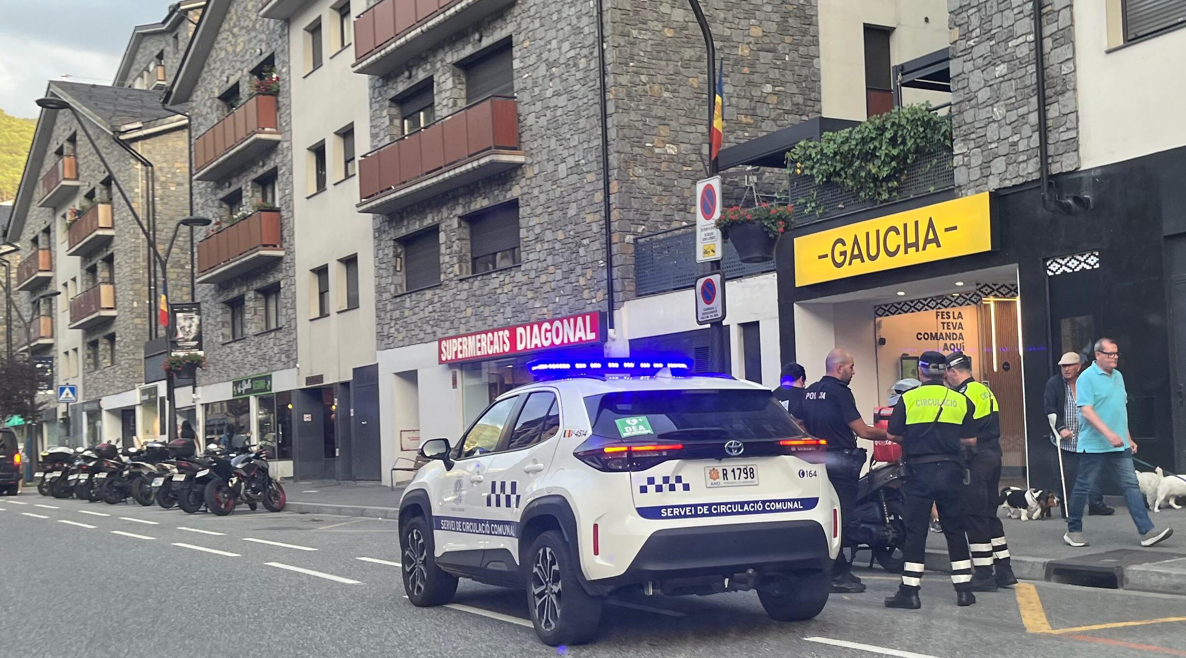 Els agents de policia i del servei de circulació parlant amb l'implicat, que no té cap lligam amb el local que apareix en la imatge.