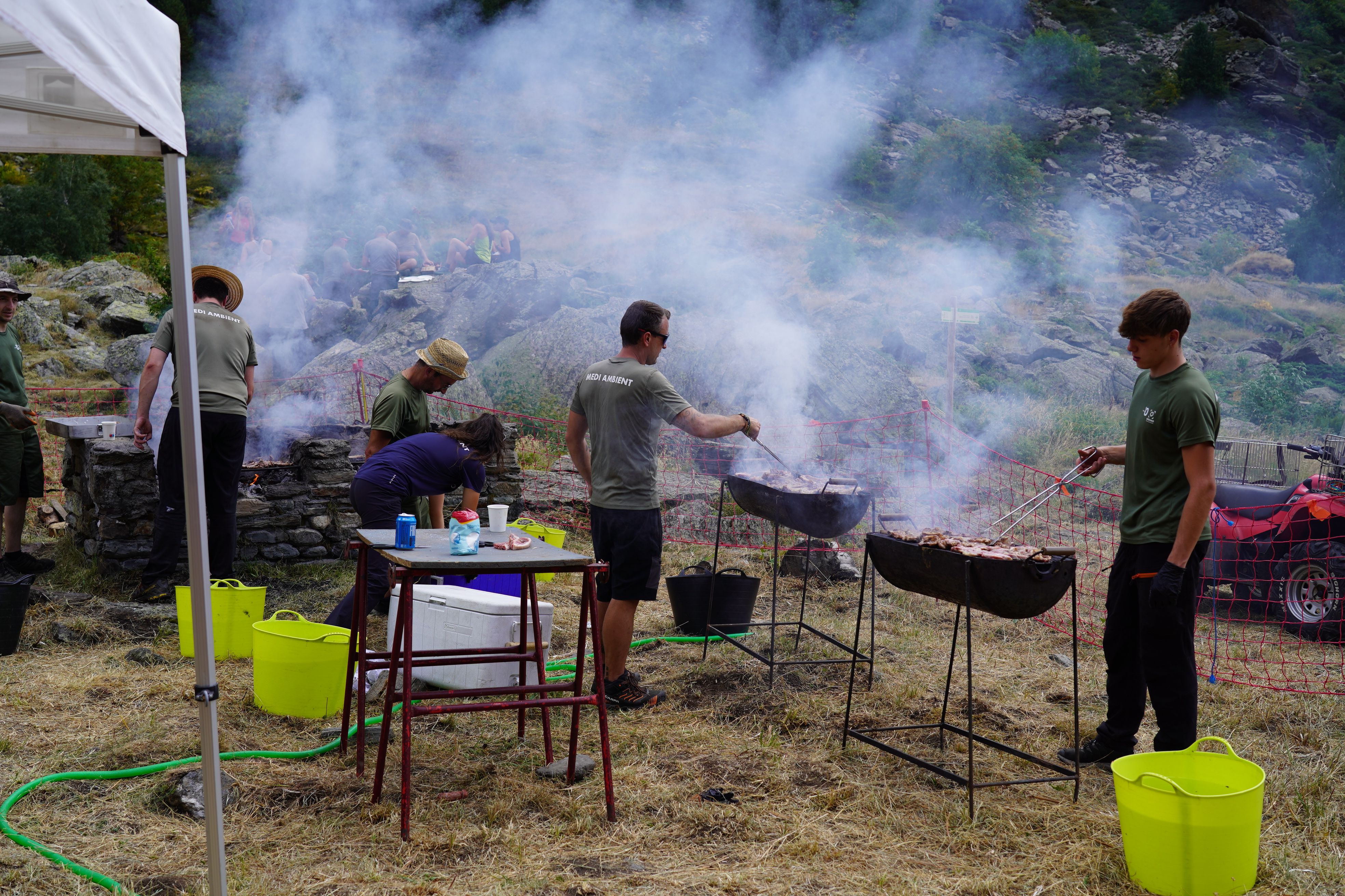 Voluntaris de Medi Ambient preparant la carn.