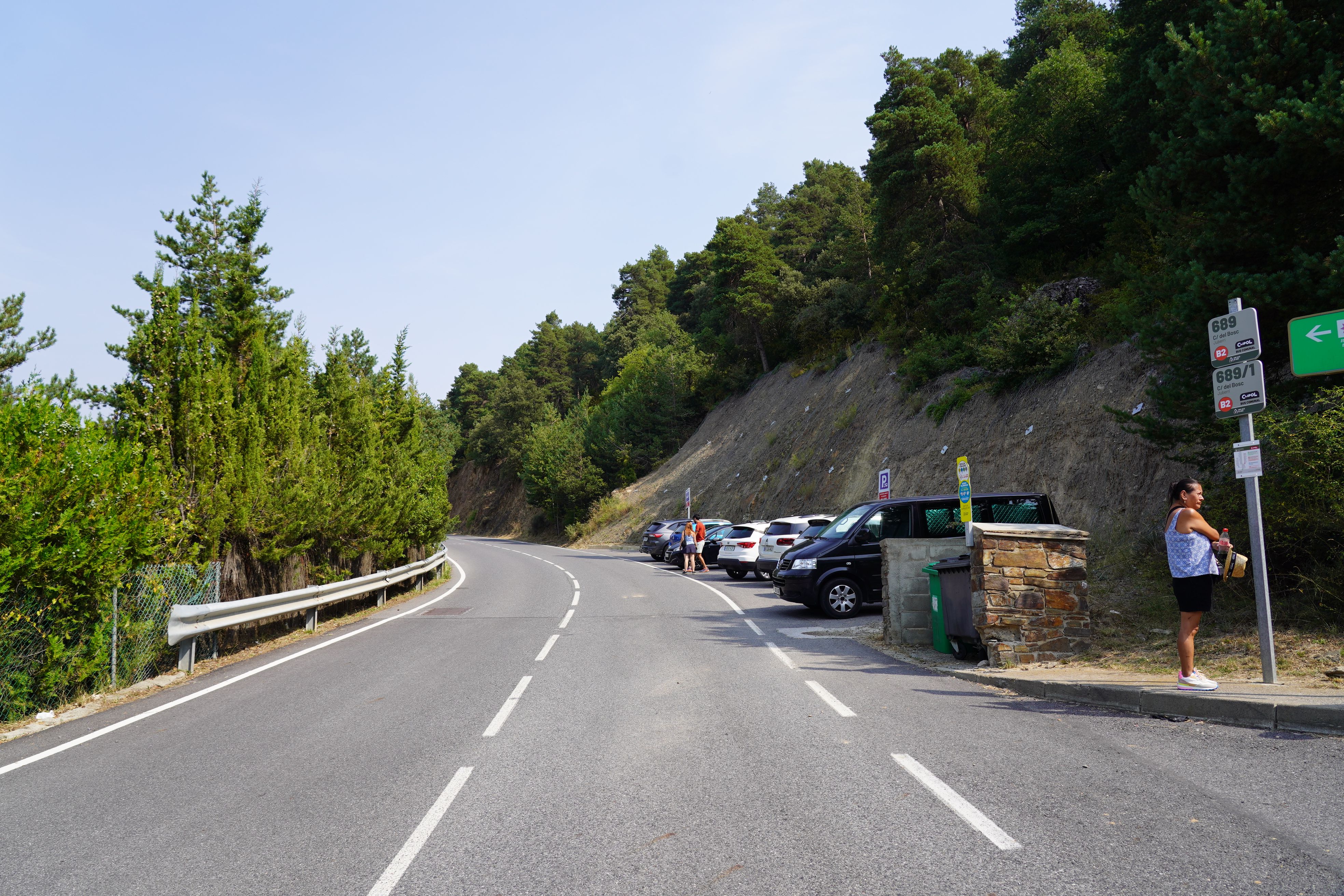 Cotxes aparcats al petit pàrquing que hi ha a la carretera que travessa el poble.