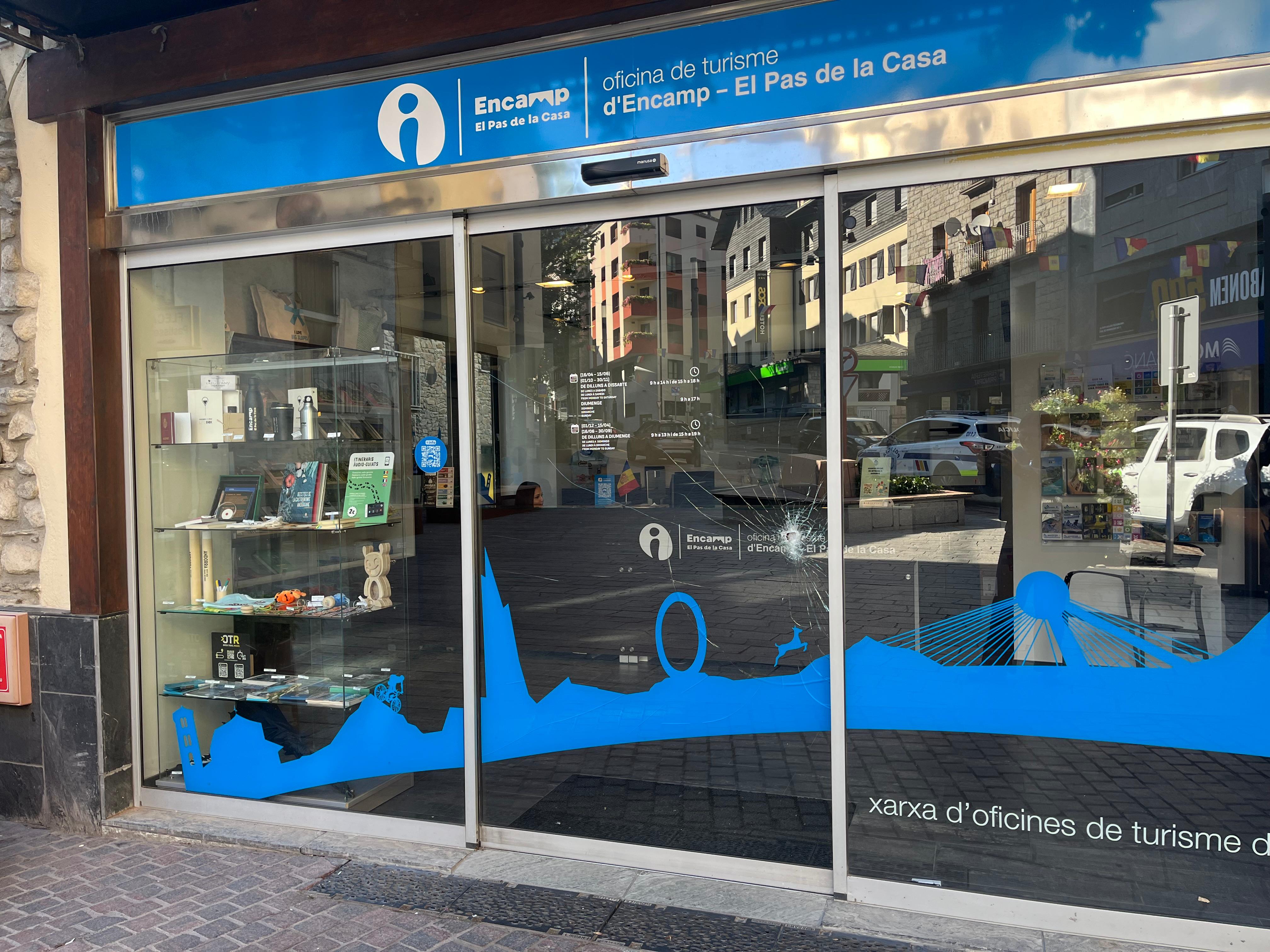 L'oficina 'atacada' amb el cop de martell al mig i un cotxe de policia reflectit al vidre. L'oficina 'atacada' amb el cop de martell al mig i un cotxe de policia reflectit al vidre.