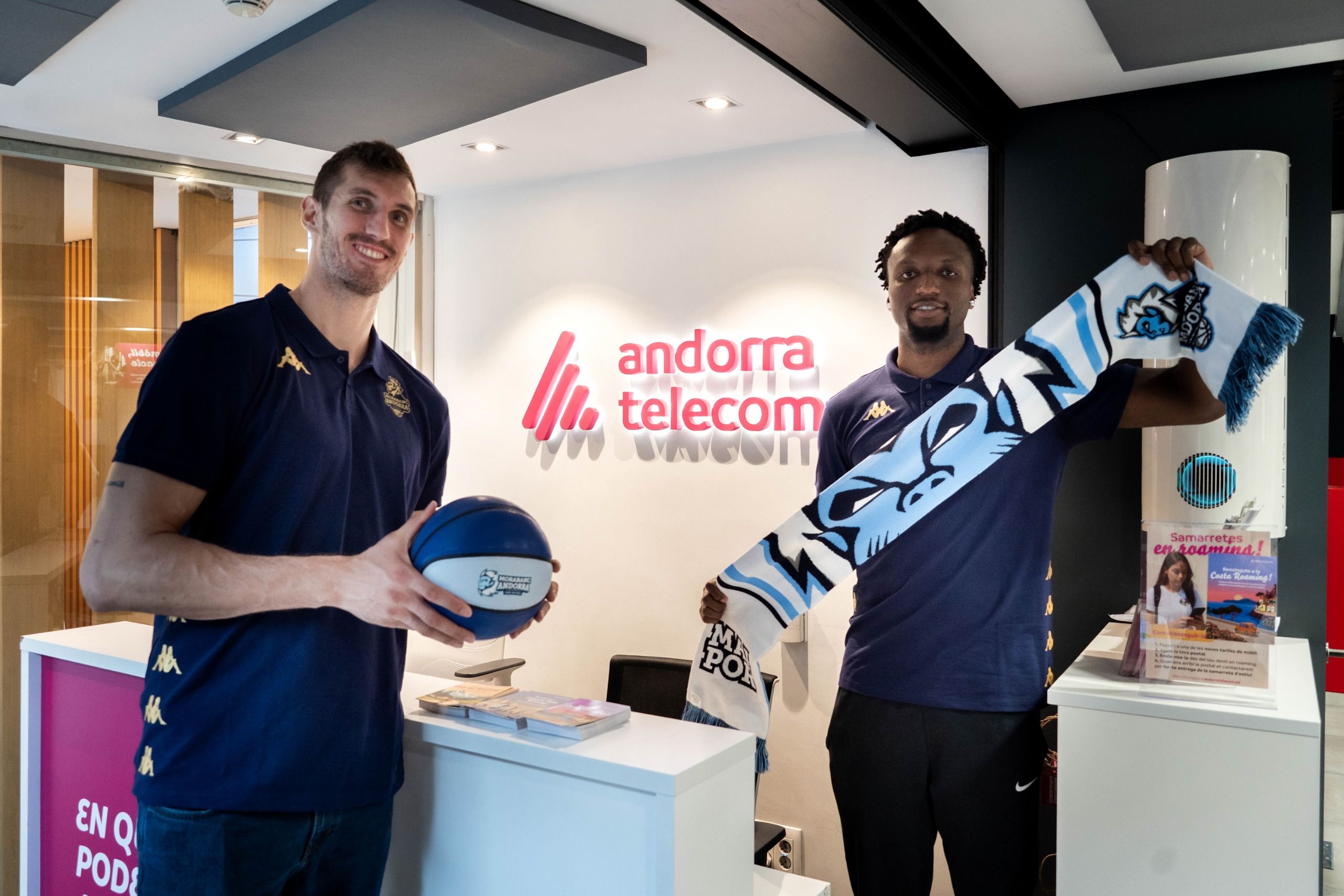 Els dos pivots, a l'entrada de la seu central d'Andorra Telecom amb el merchandising del club.