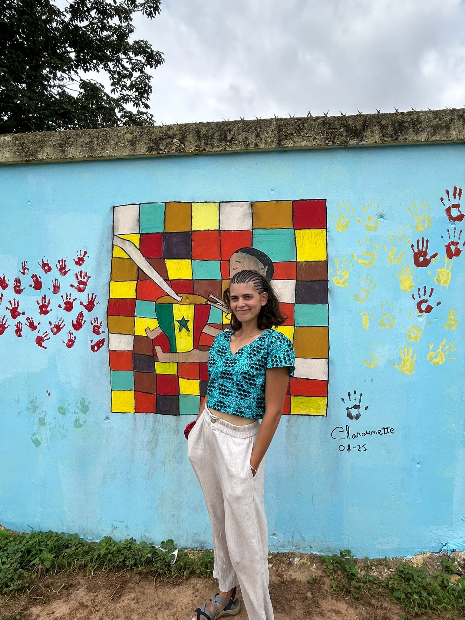 Clara Codina Navarro davant d'un mural i que va pintar amb ajuda d'alguns dels nois de l'orfenat d'Mbour.