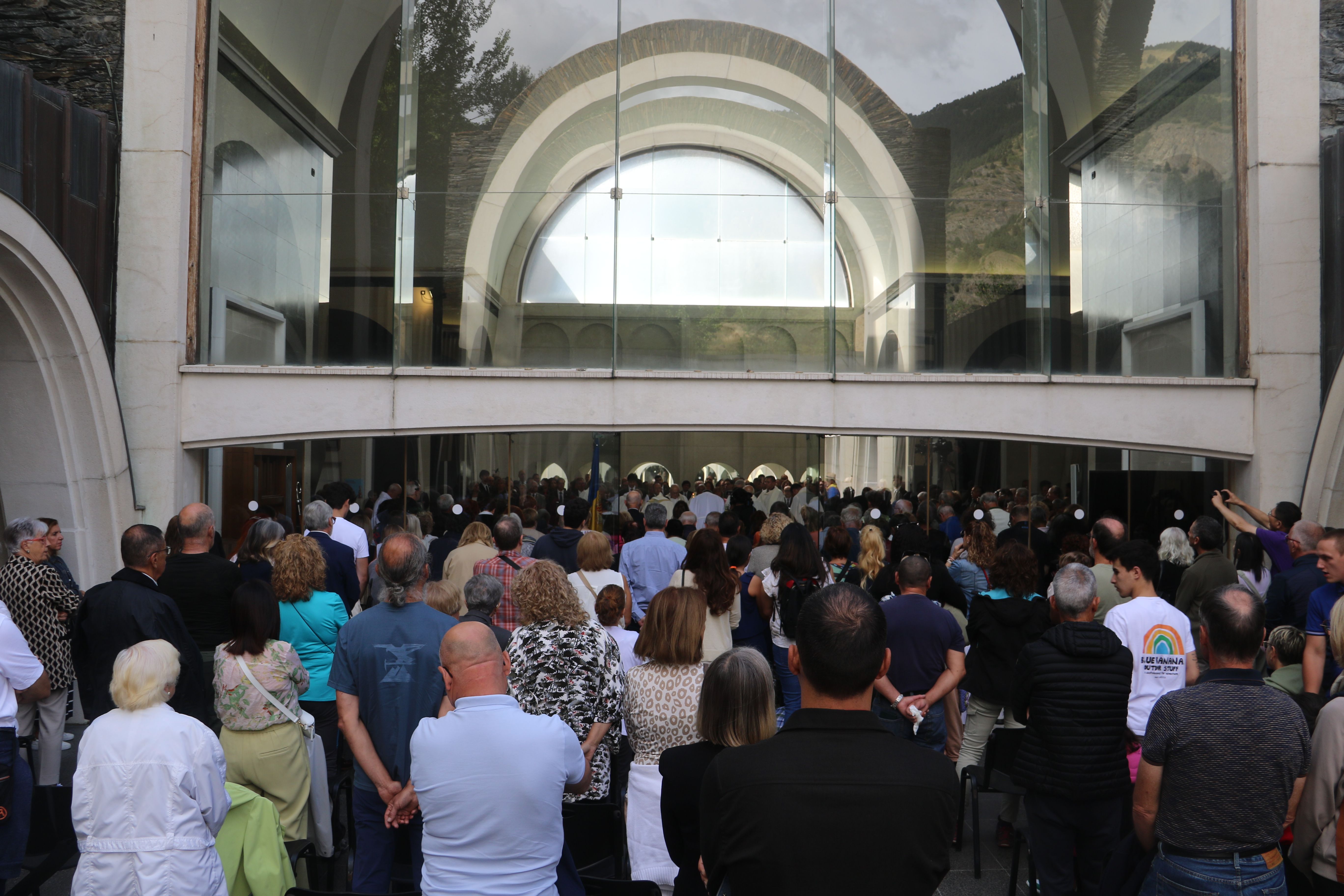 Fidels seguint la missa des del claustre.