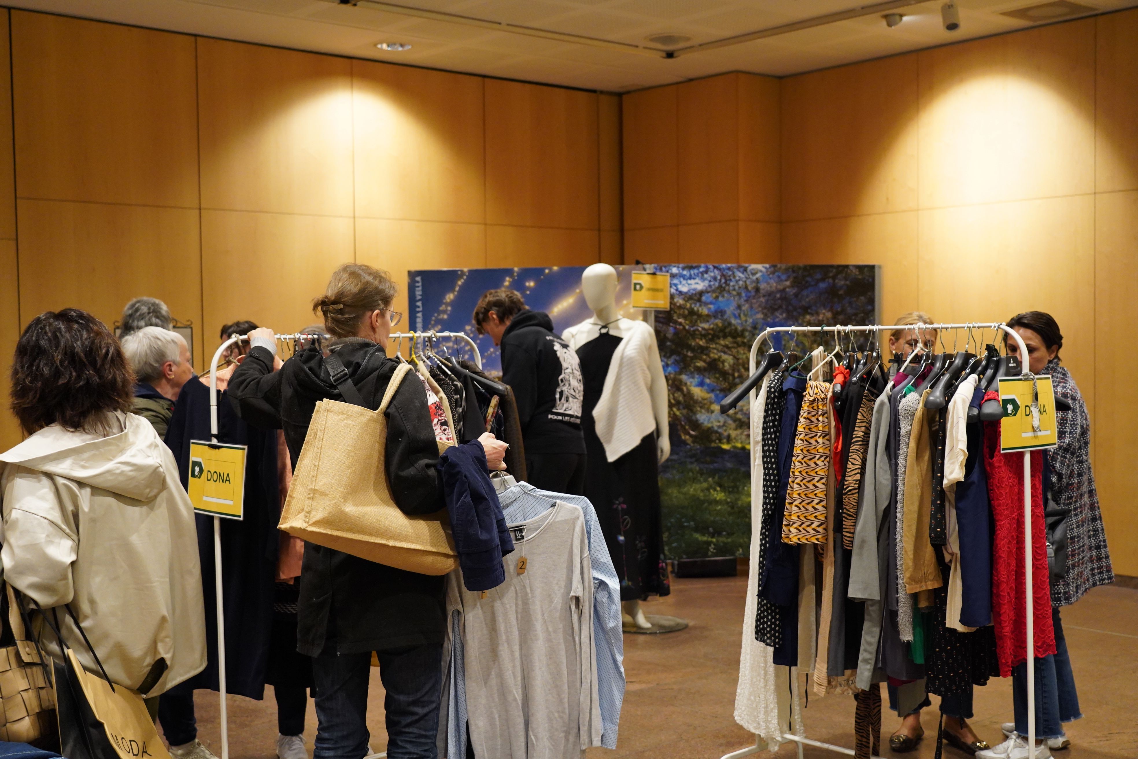 Grups de dones i també algun home, regirant entre els penja-robes. Grups de dones i també algun home, regirant entre els penja-robes.