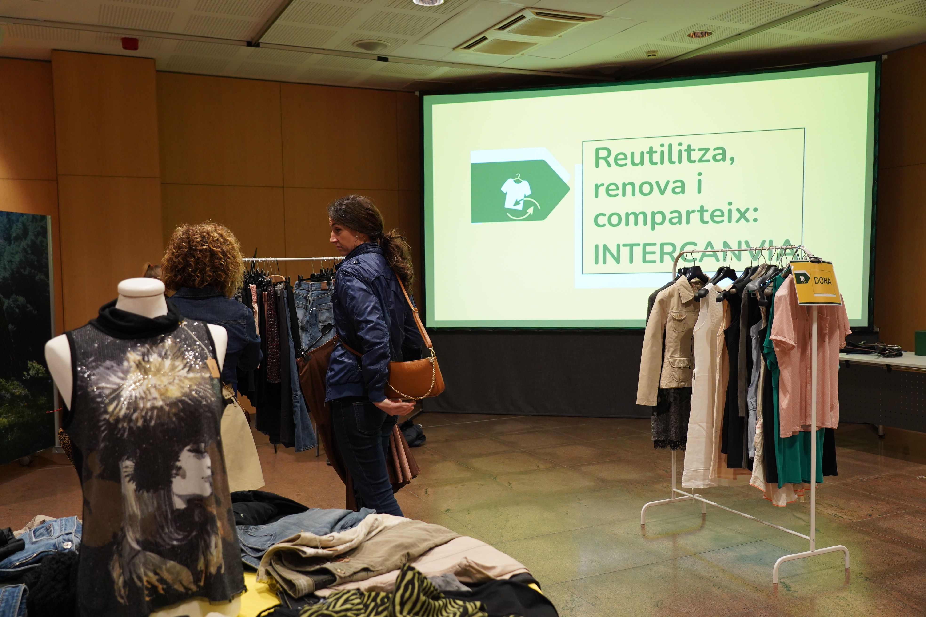 Una pantalla recorda la importància de reutilitzar la roba. Una pantalla recorda la importància de reutilitzar la roba.