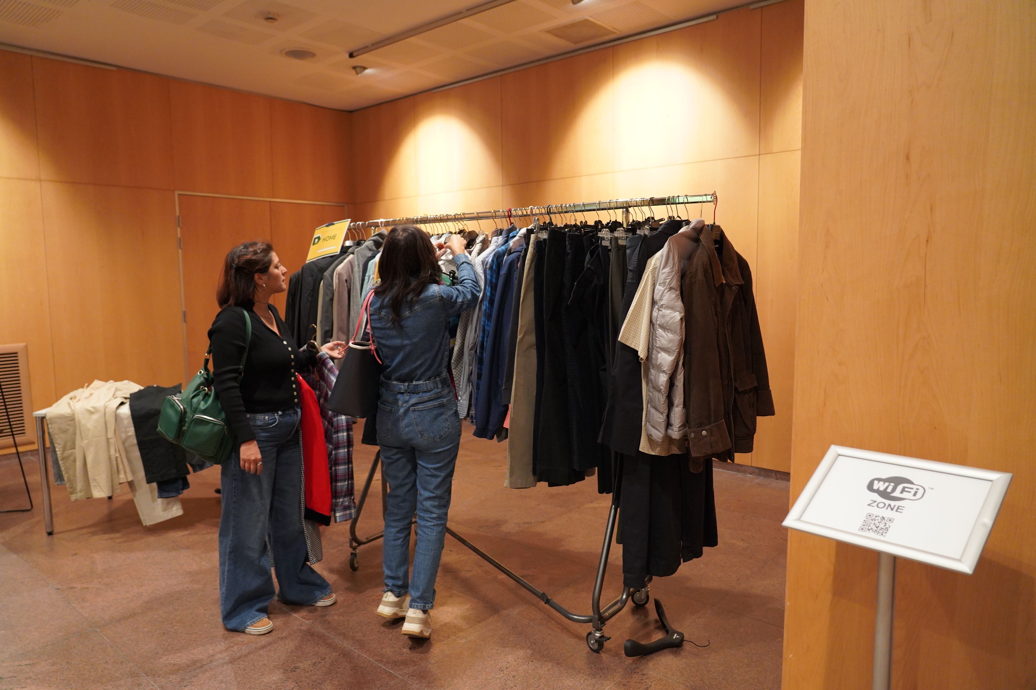 Dues dones, examinant el vestuari d'El Troc. Dues dones, examinant el vestuari d'El Troc.