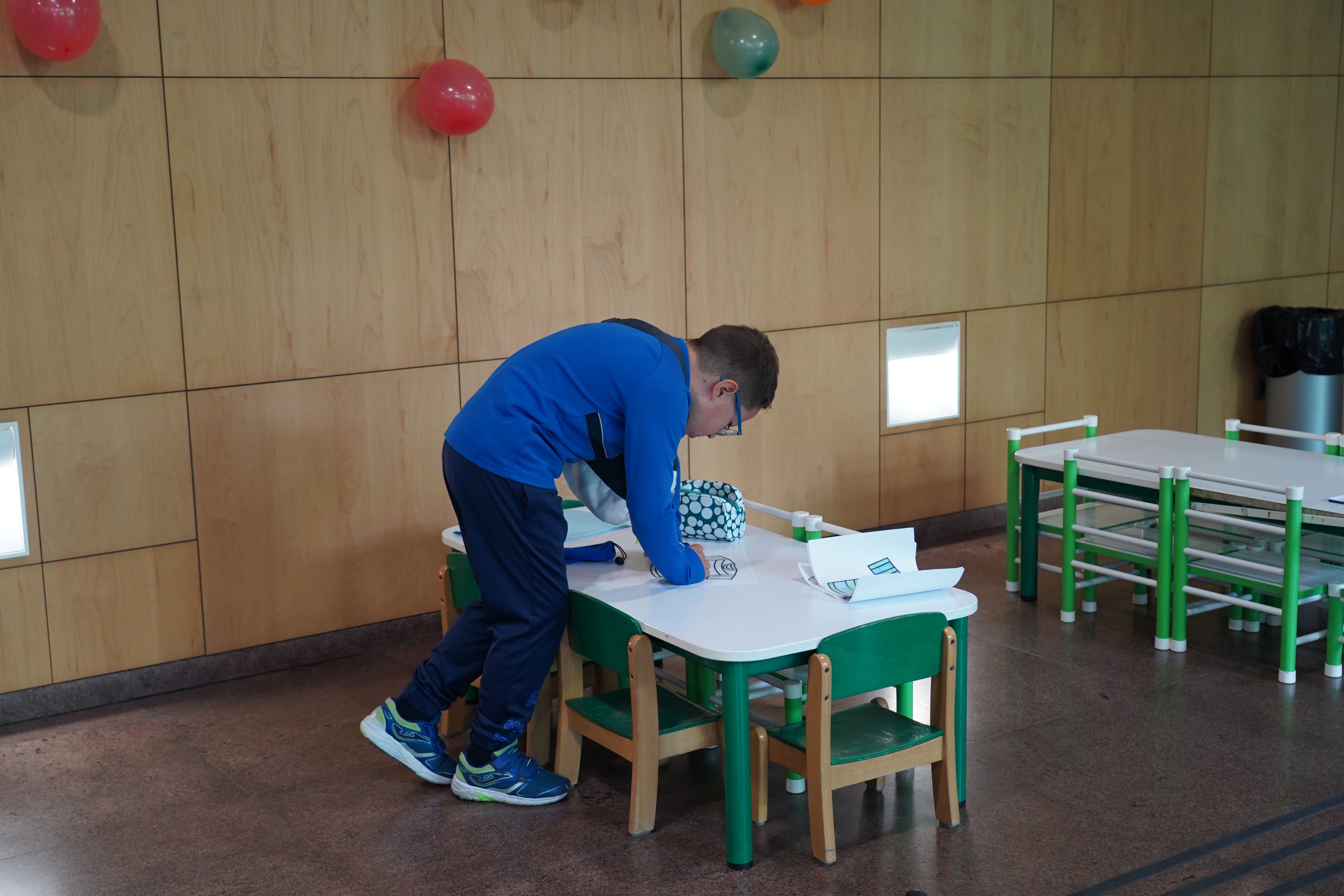 Un noi, dibuixant al taller infantil. Un noi, dibuixant al taller infantil.