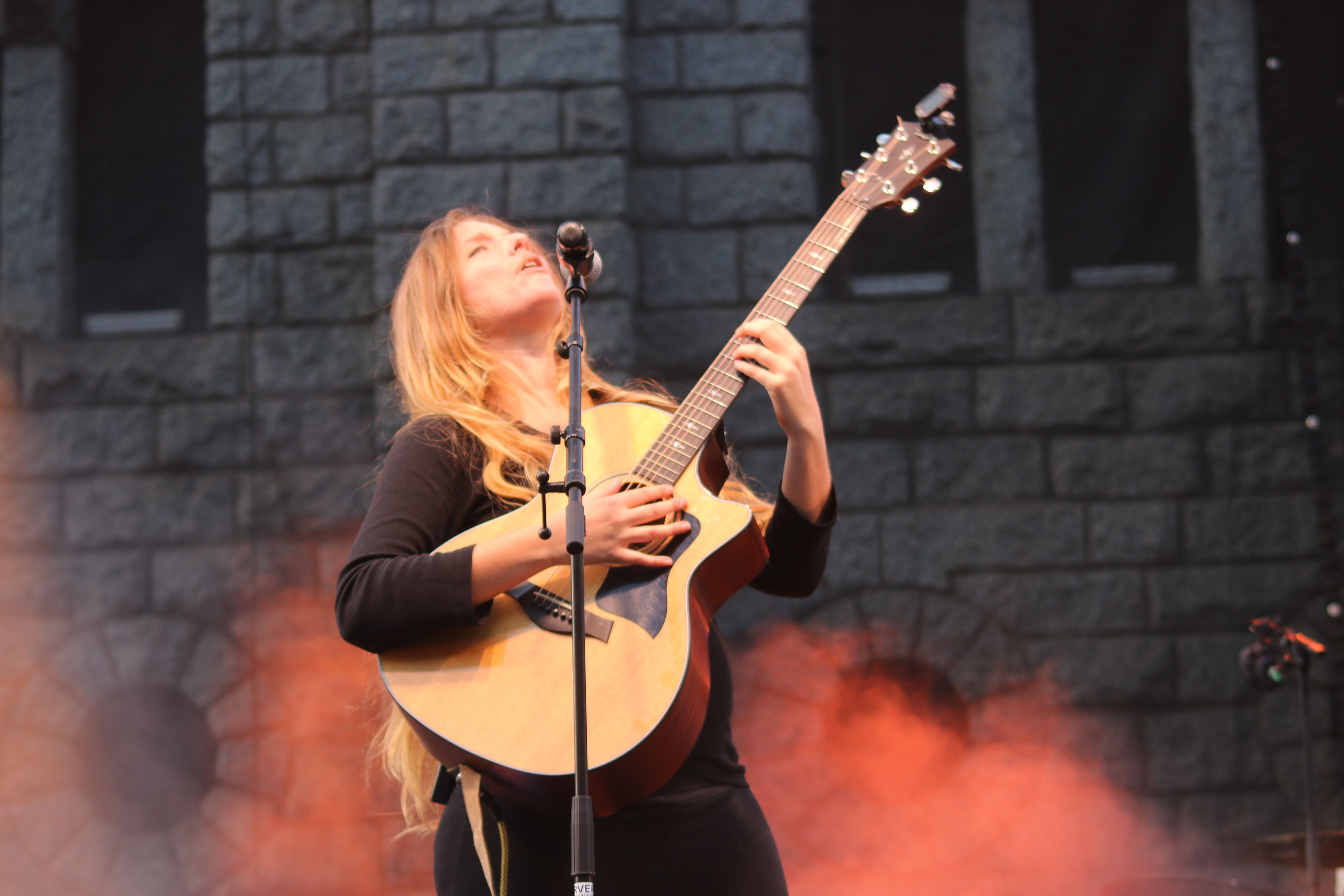 Alidé Sans entonant una cançó a la guitarra.