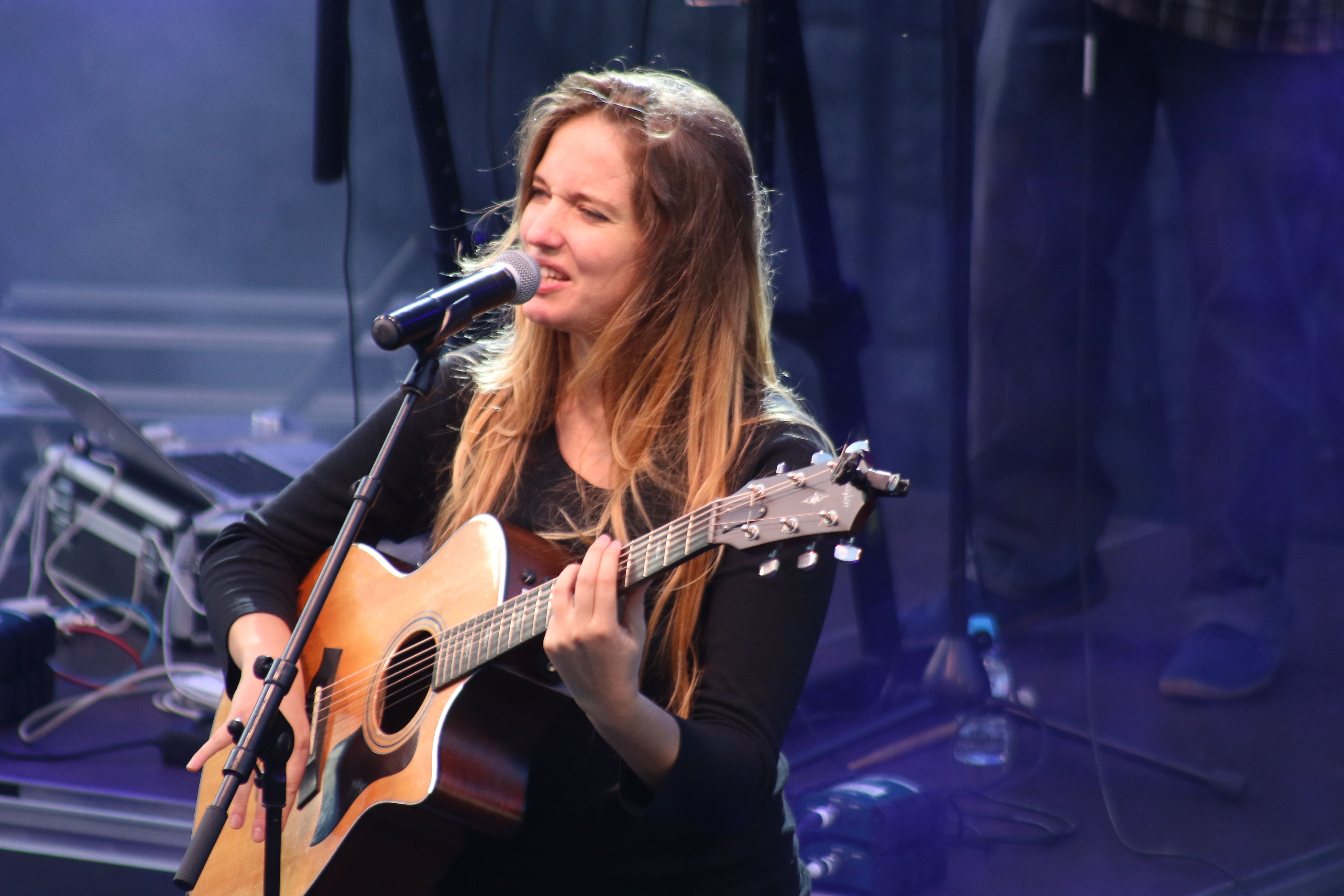 Alidé Sans entonant una cançó a la guitarra.