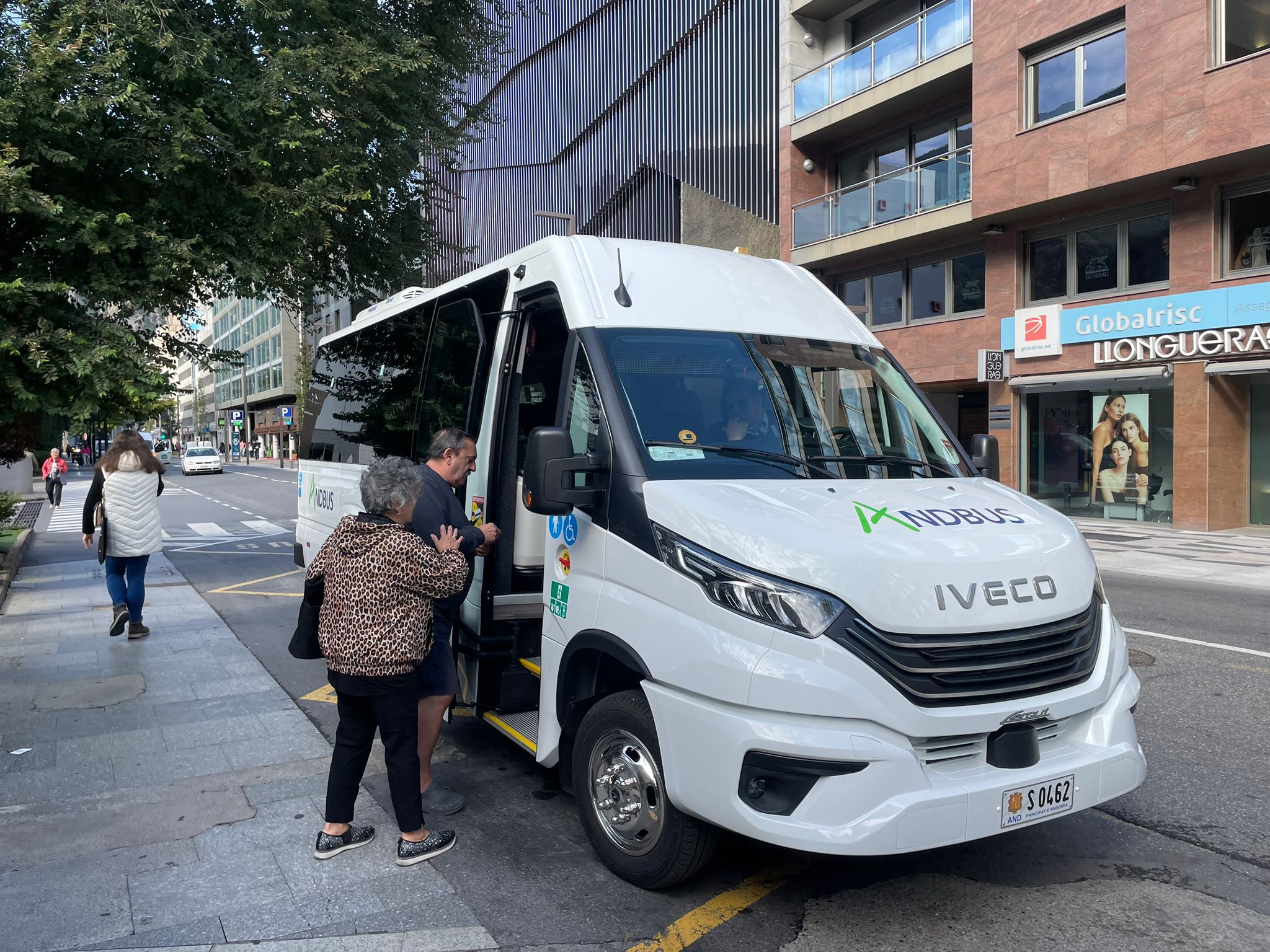 Dos usuaris pugen al bus interparroquial a Prat de la Creu.