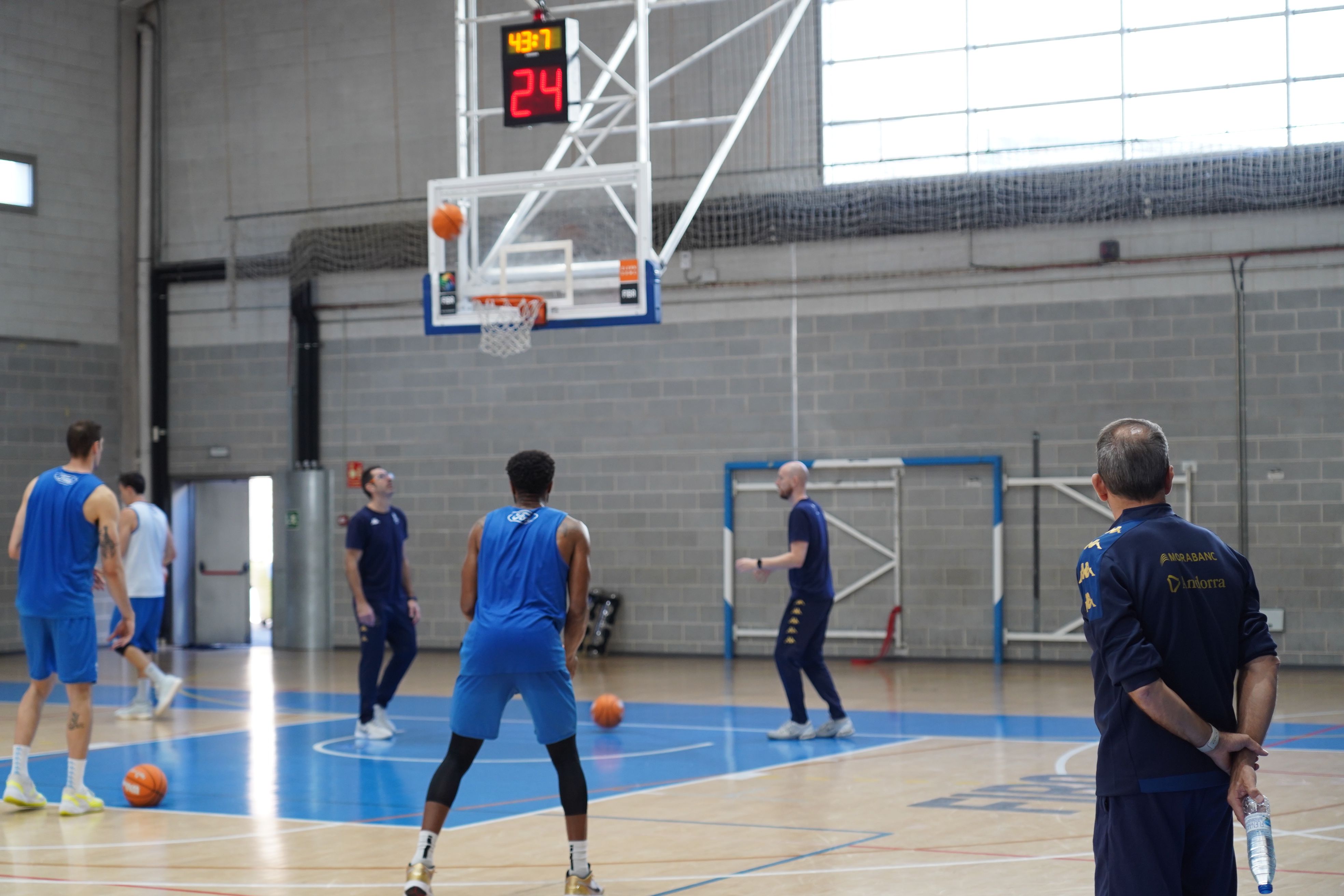Els jugadors del MoraBanc Andorra, llençant a cistella sota la mirada de Joan Plaza.