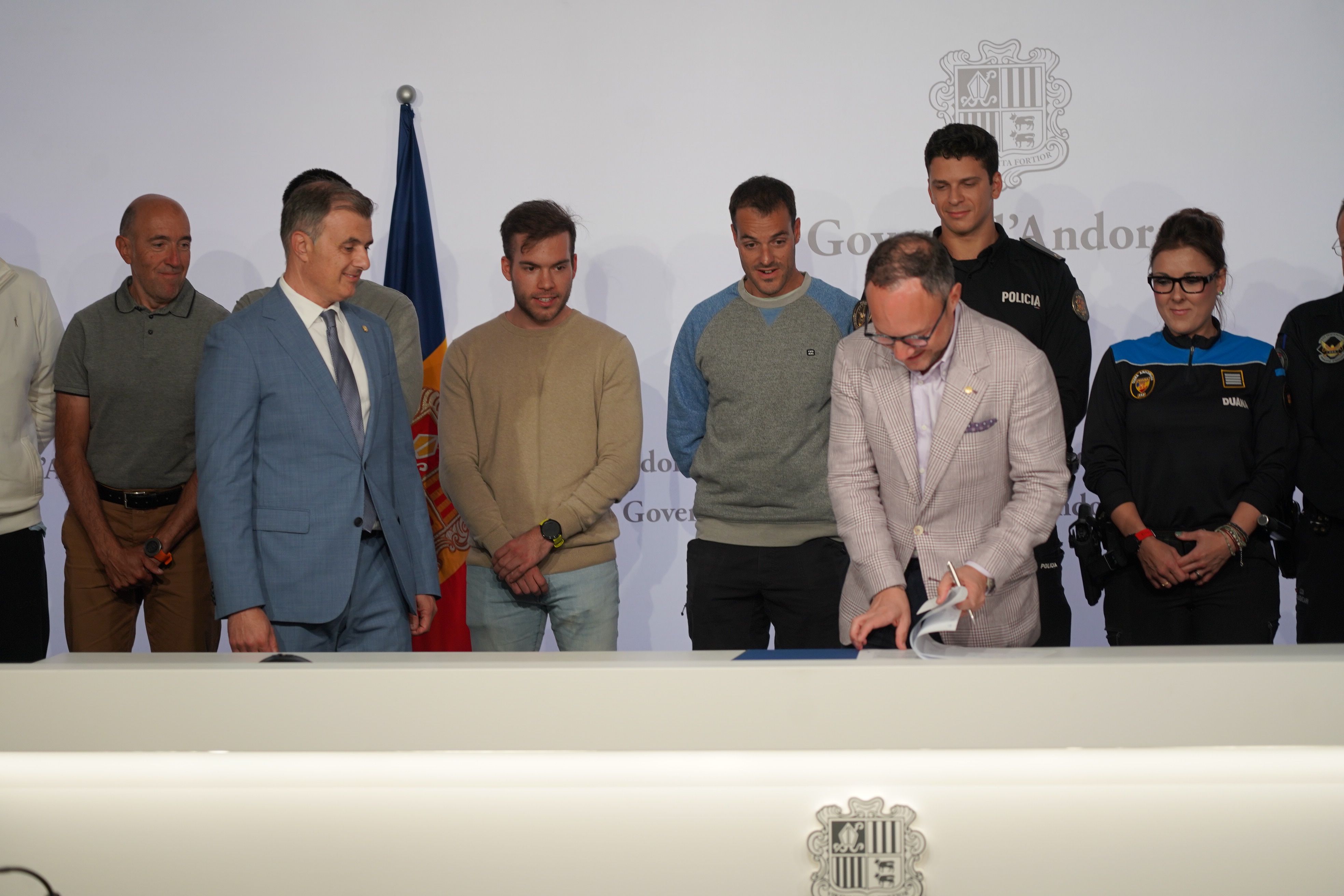 Xavier Espot signant l'acord sota la mirada dels funcionaris sindicalistes i el ministre Marc Rossell.