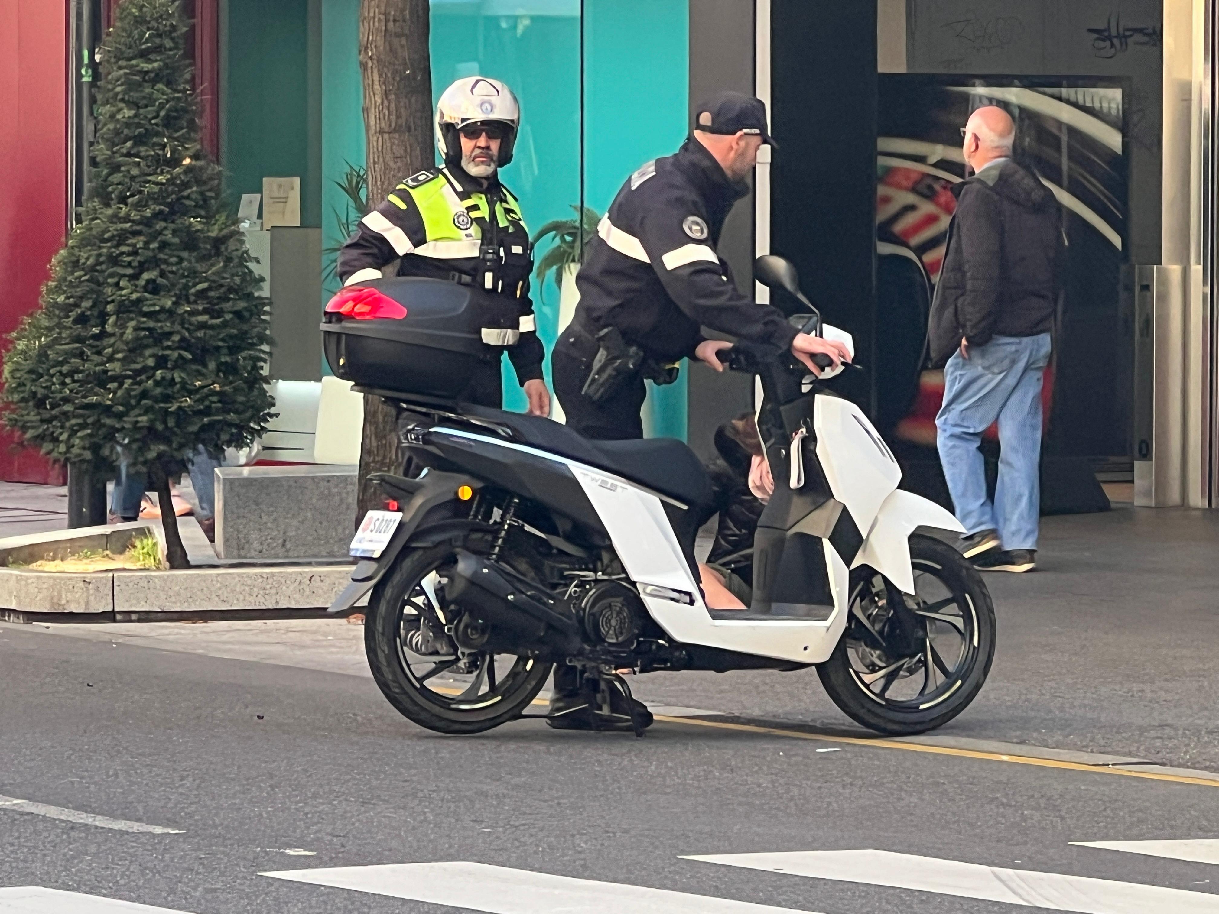 Un policia aparta la moto del mig del carrer. Un policia aparta la moto del mig del carrer.