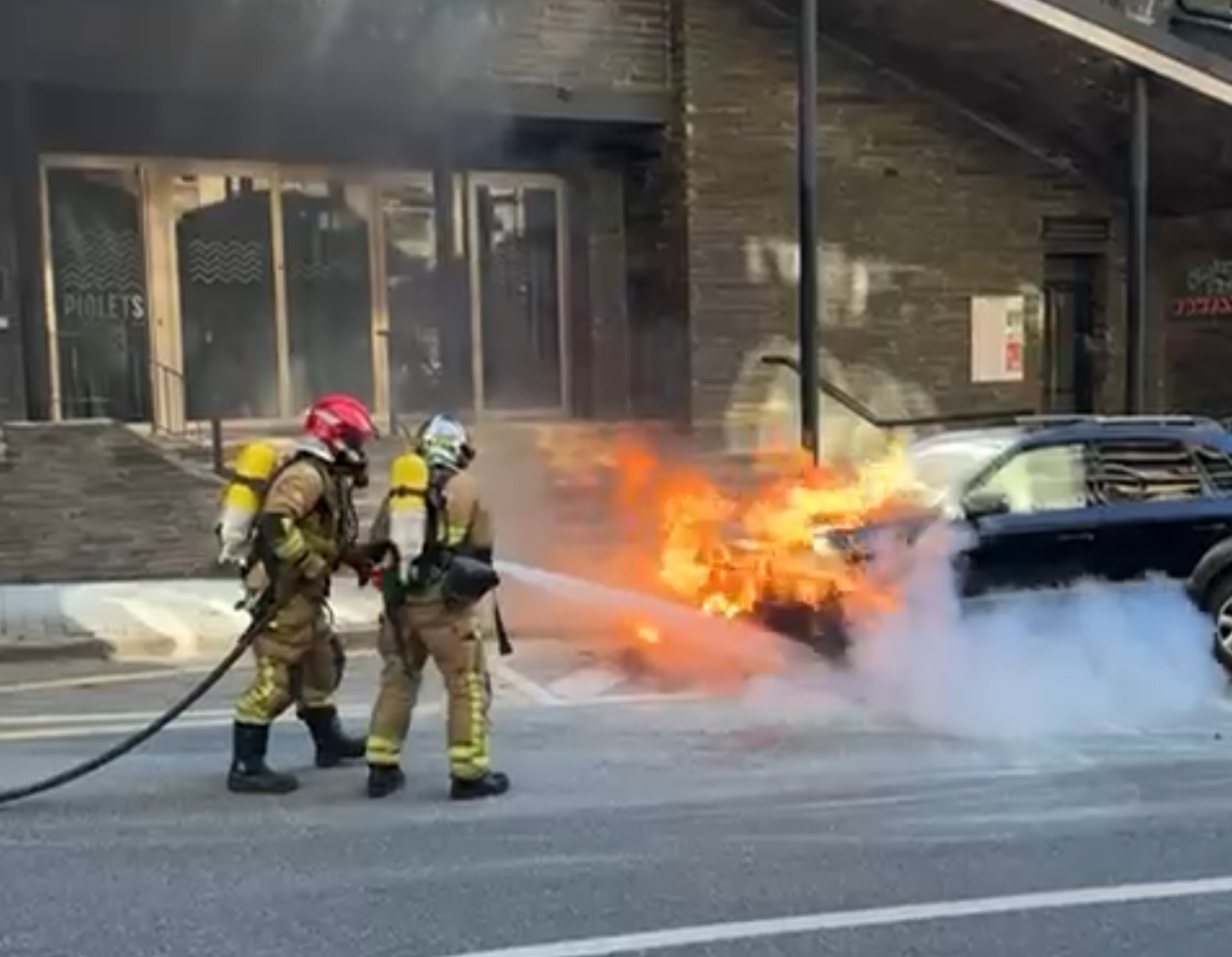 Els bombers actuant per apagar les flames.