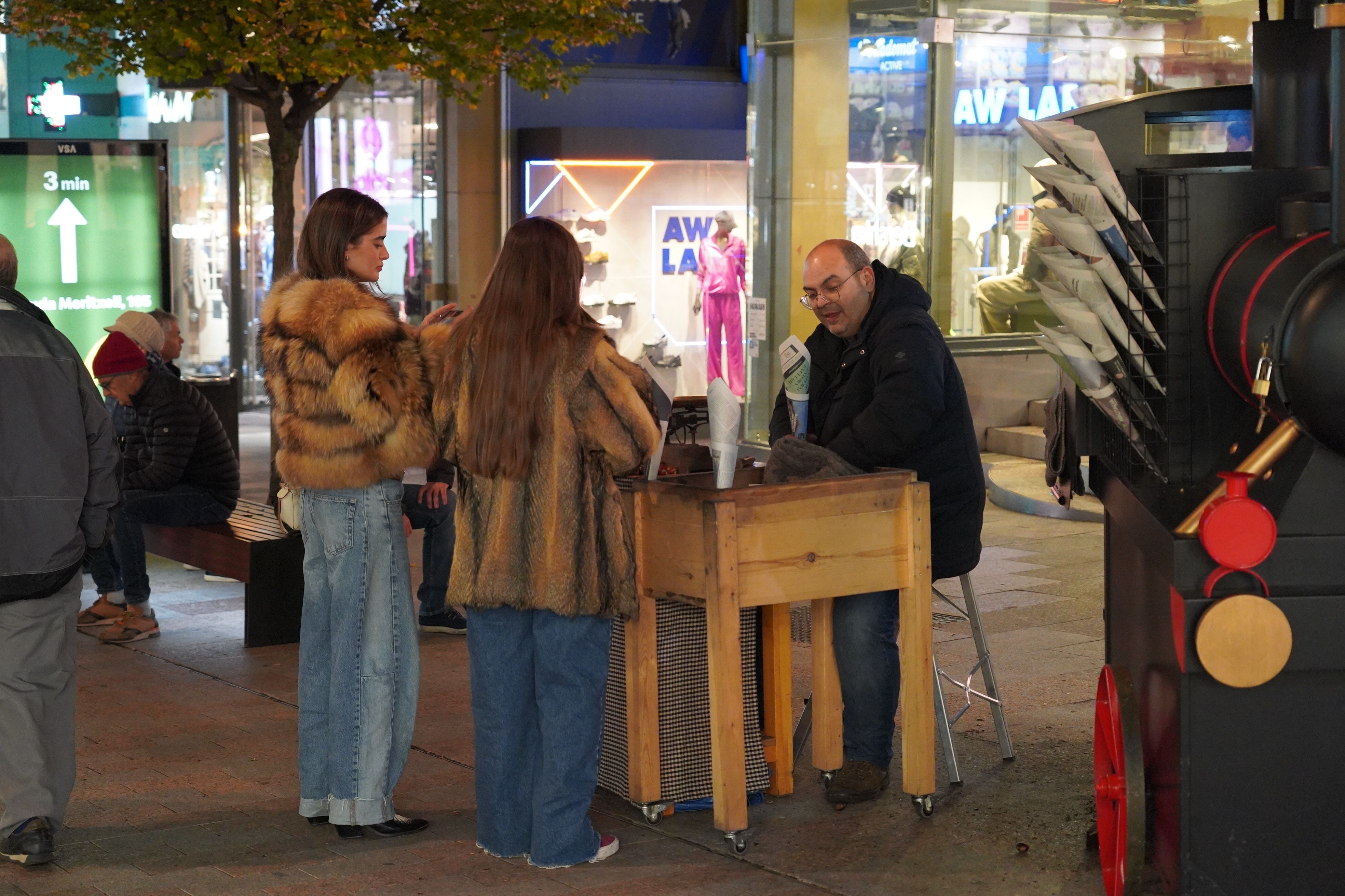 Dues noies comprant castanyes a l'avinguda Carlemany.