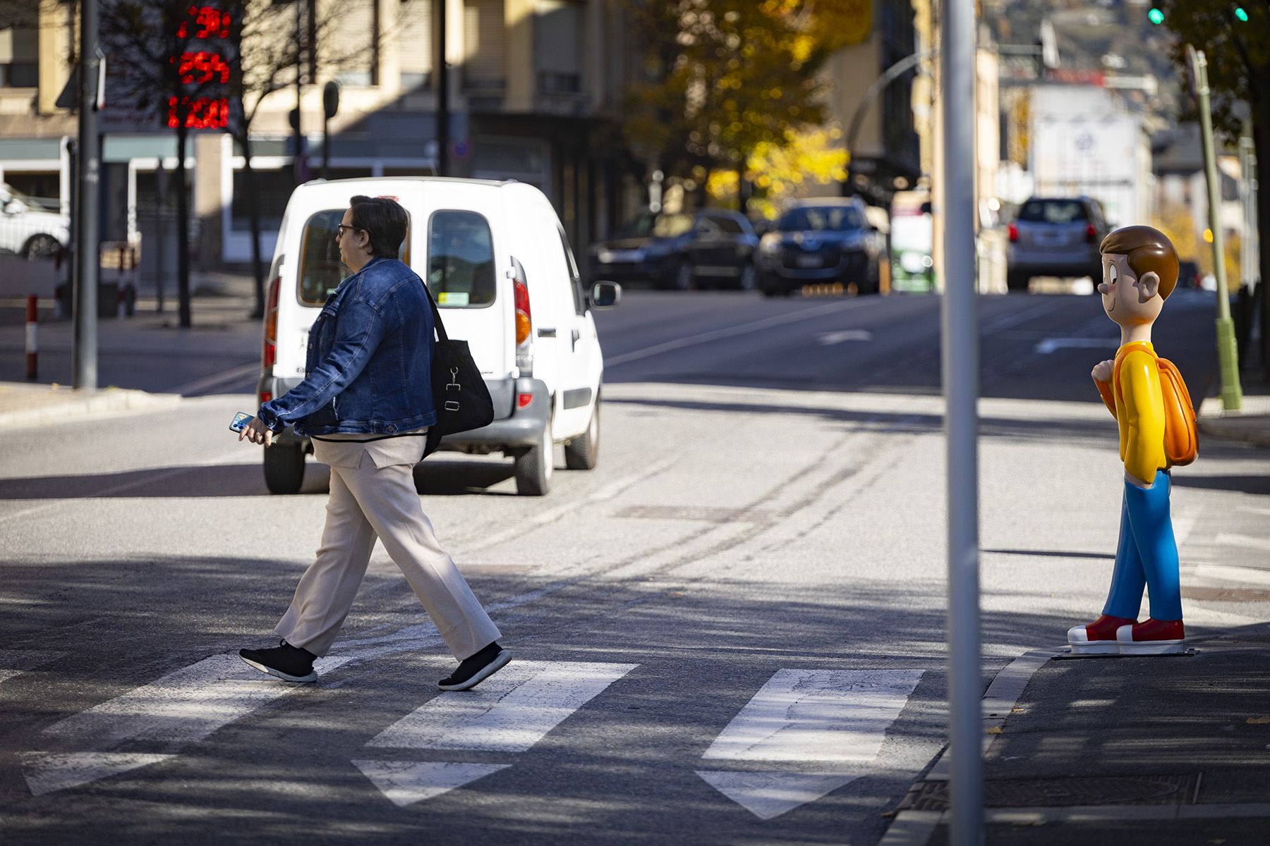 Una senyora creua en un pas de vianants on ja s'hi ha col·locat la figura d'en Pau.