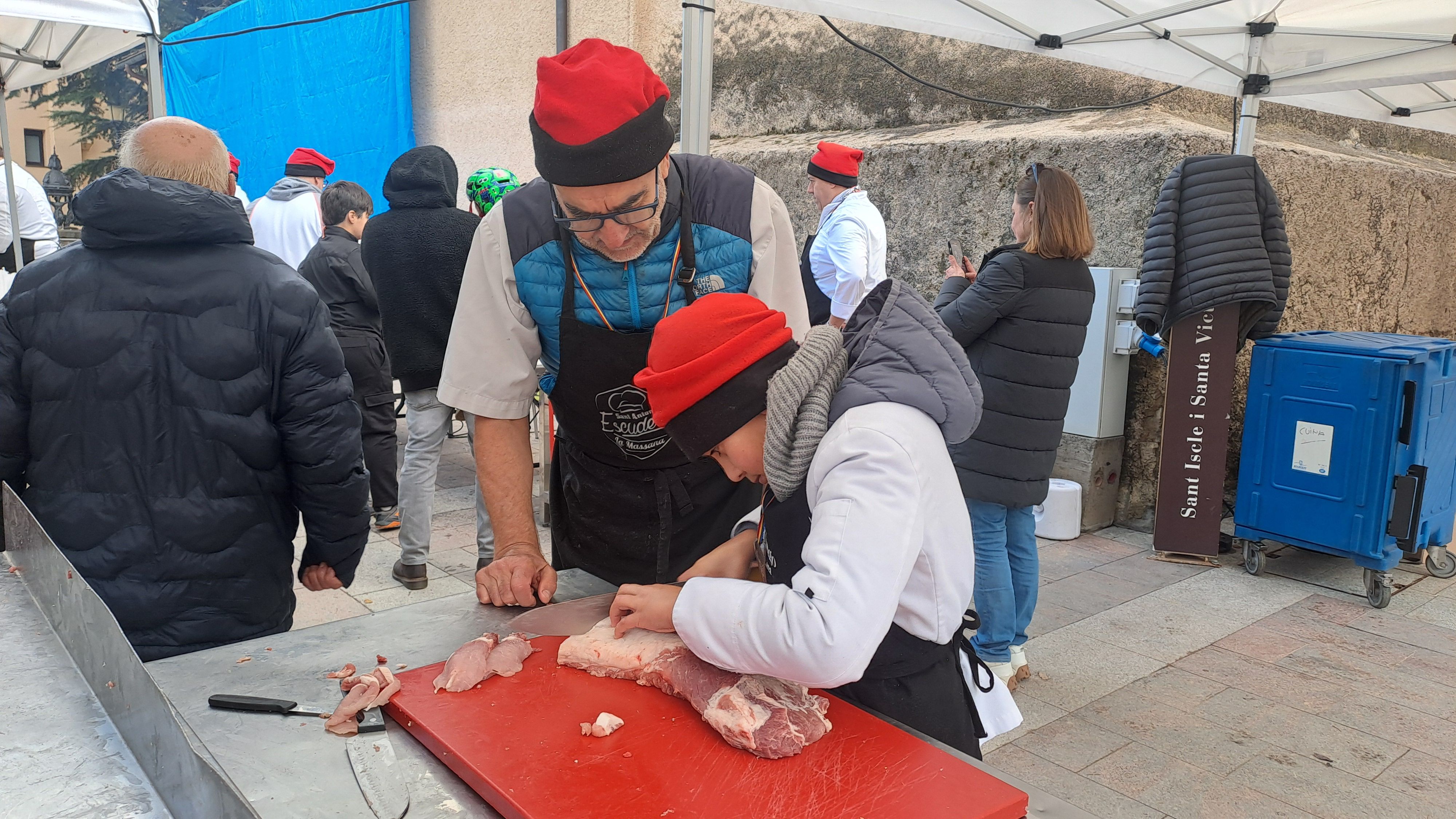 Un petit cuiner tallant carn de porc. 