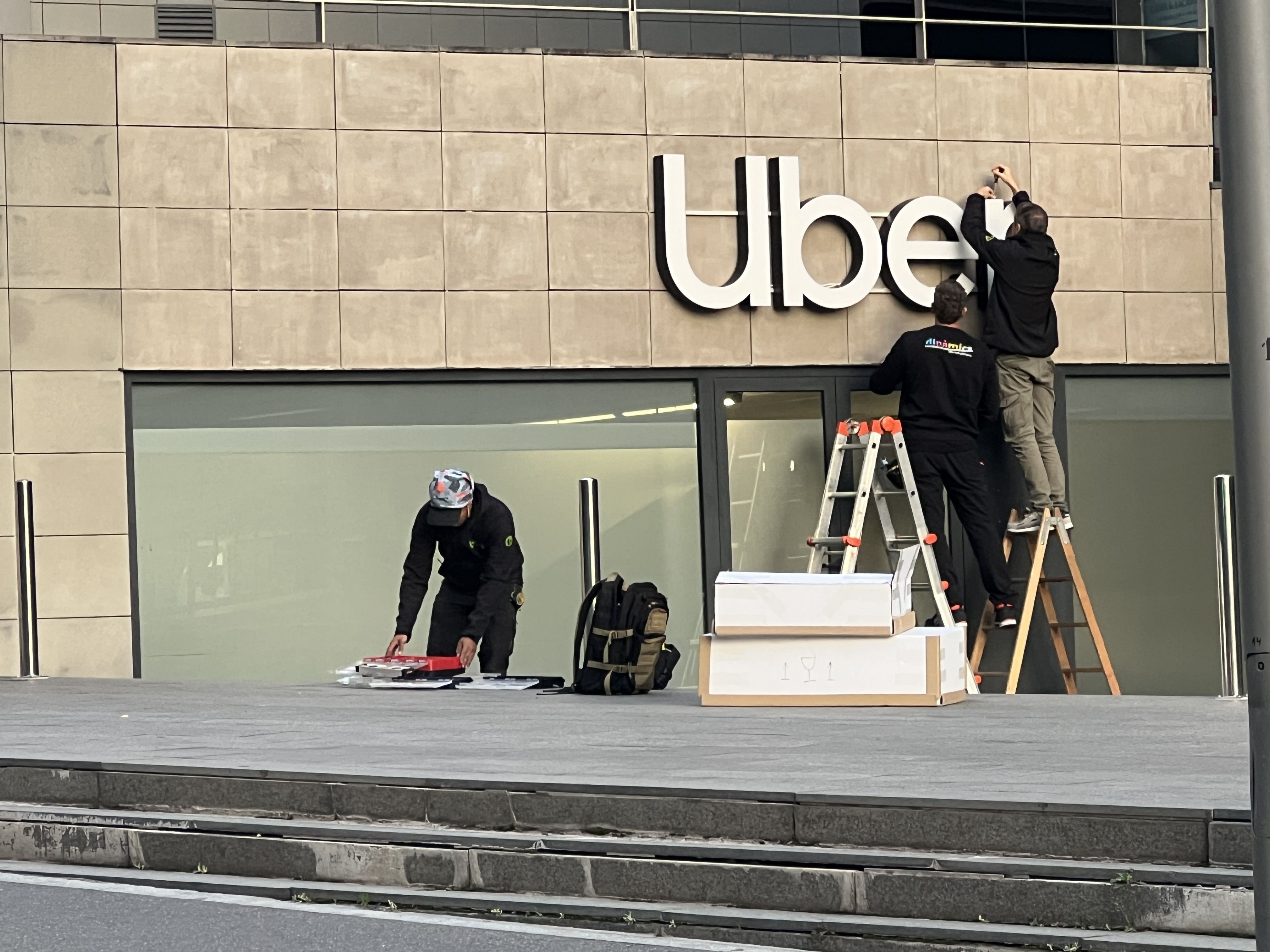 Operaris col·locant el rètol d'Uber.