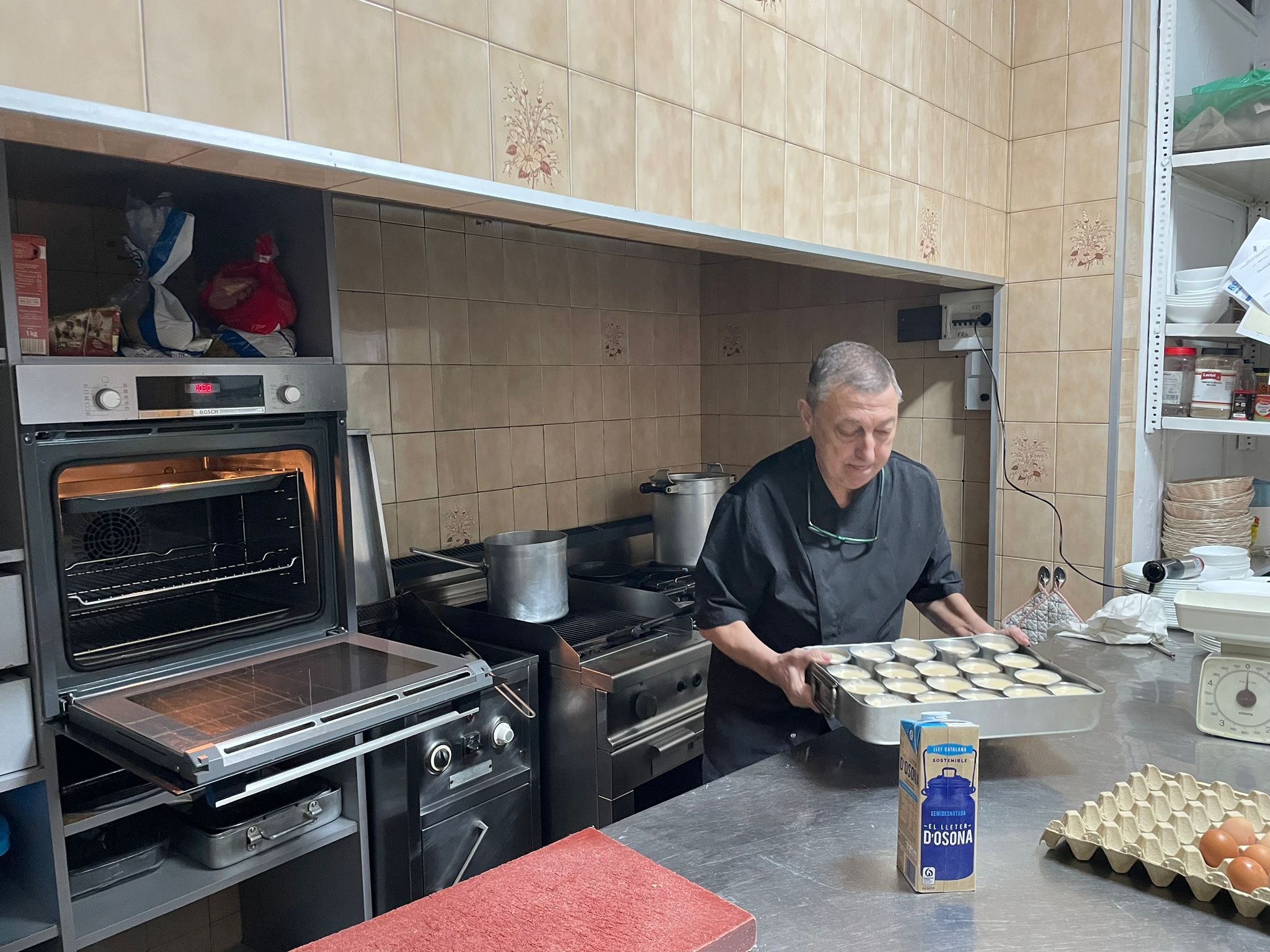 El Joan transportant una safata de flams casolans al forn.