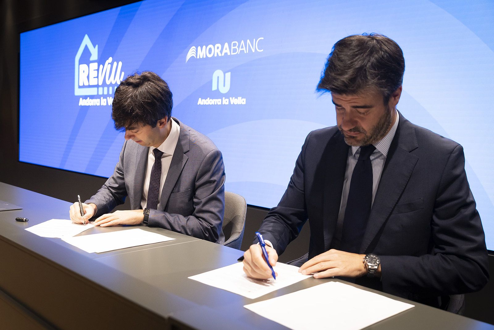 El cònsol Sergi González, signant la col·laboració amb MoraBanc juntament amb Xavier Riestra.