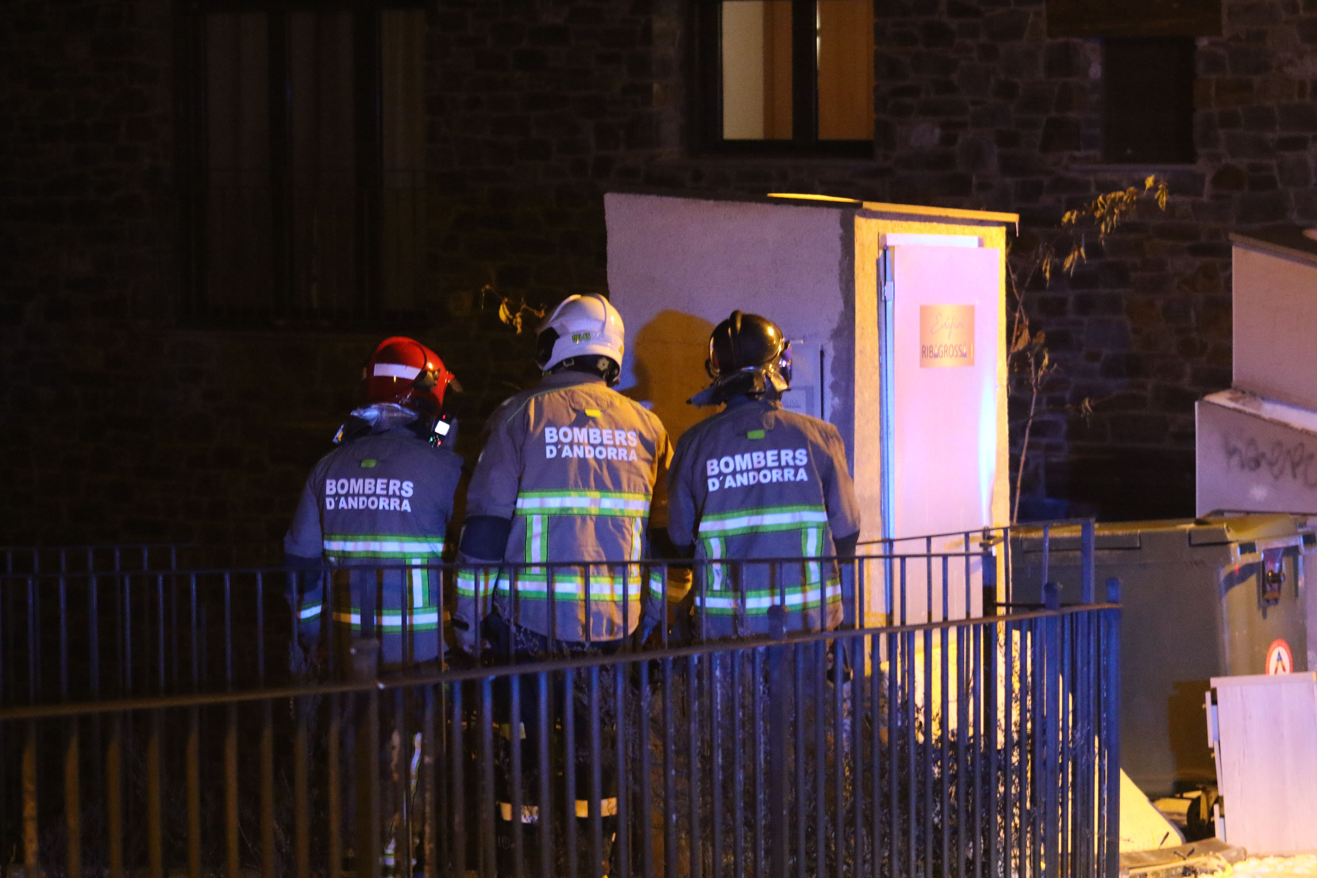 Tres dels bombers mirant l'actuació de companys seus i guiant-los i il·luminant-los.
