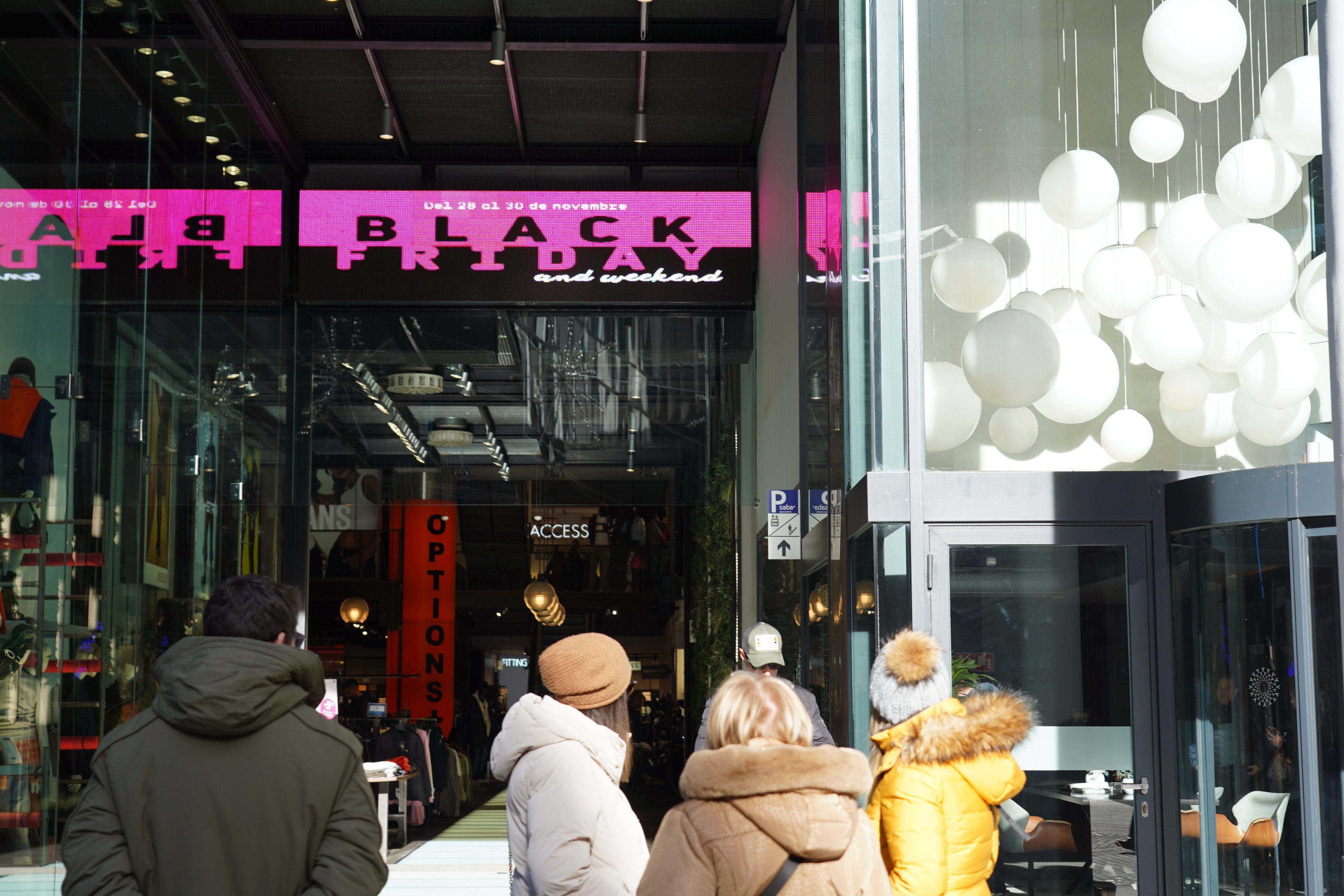 Diversos ciutadans, visualitzant els cartells del Black Friday.