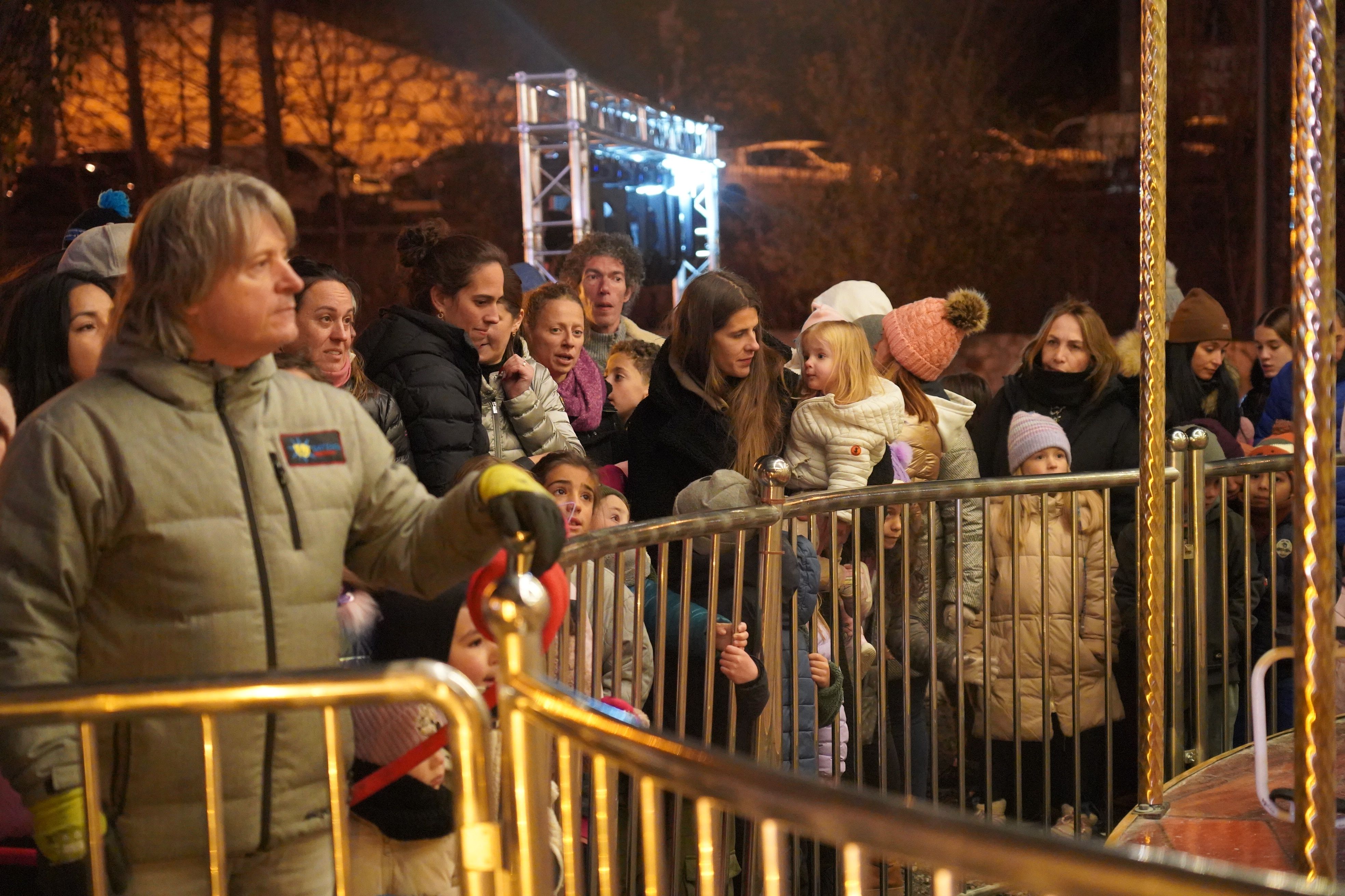 Pares i mares esperen els nens al carrusel.