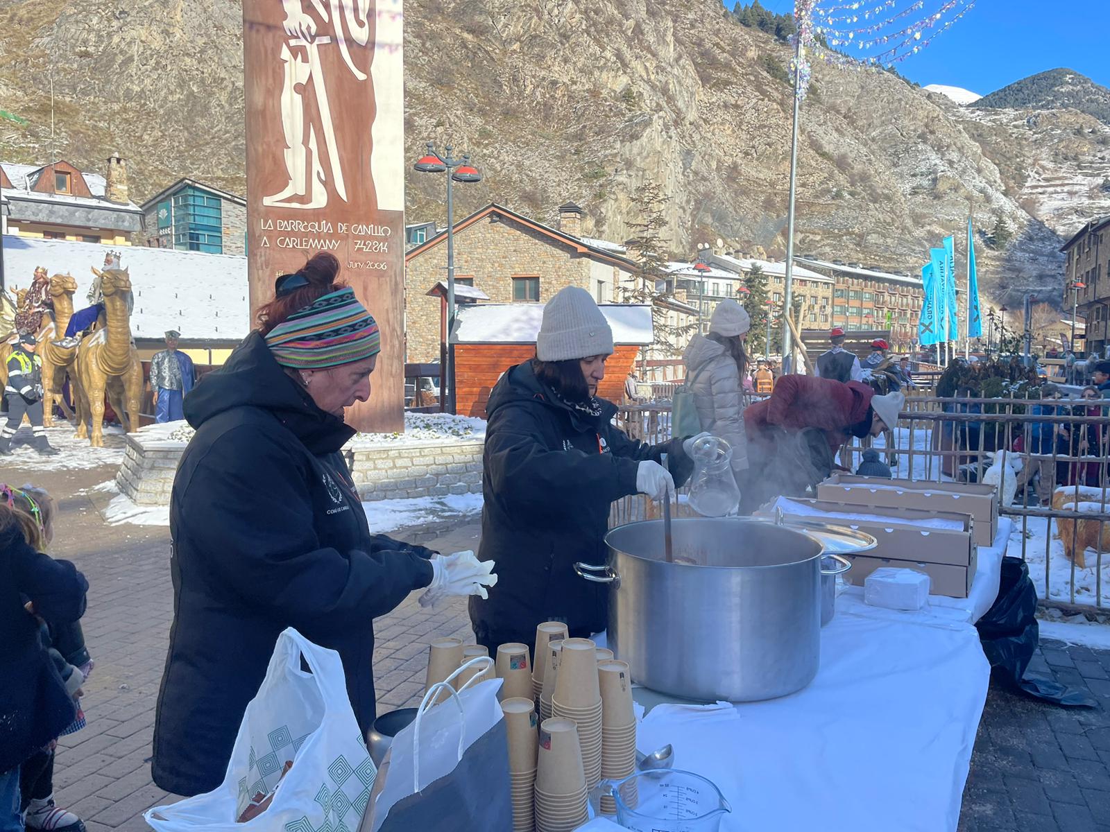 Dues voluntàries preparen xocolata desfeta.