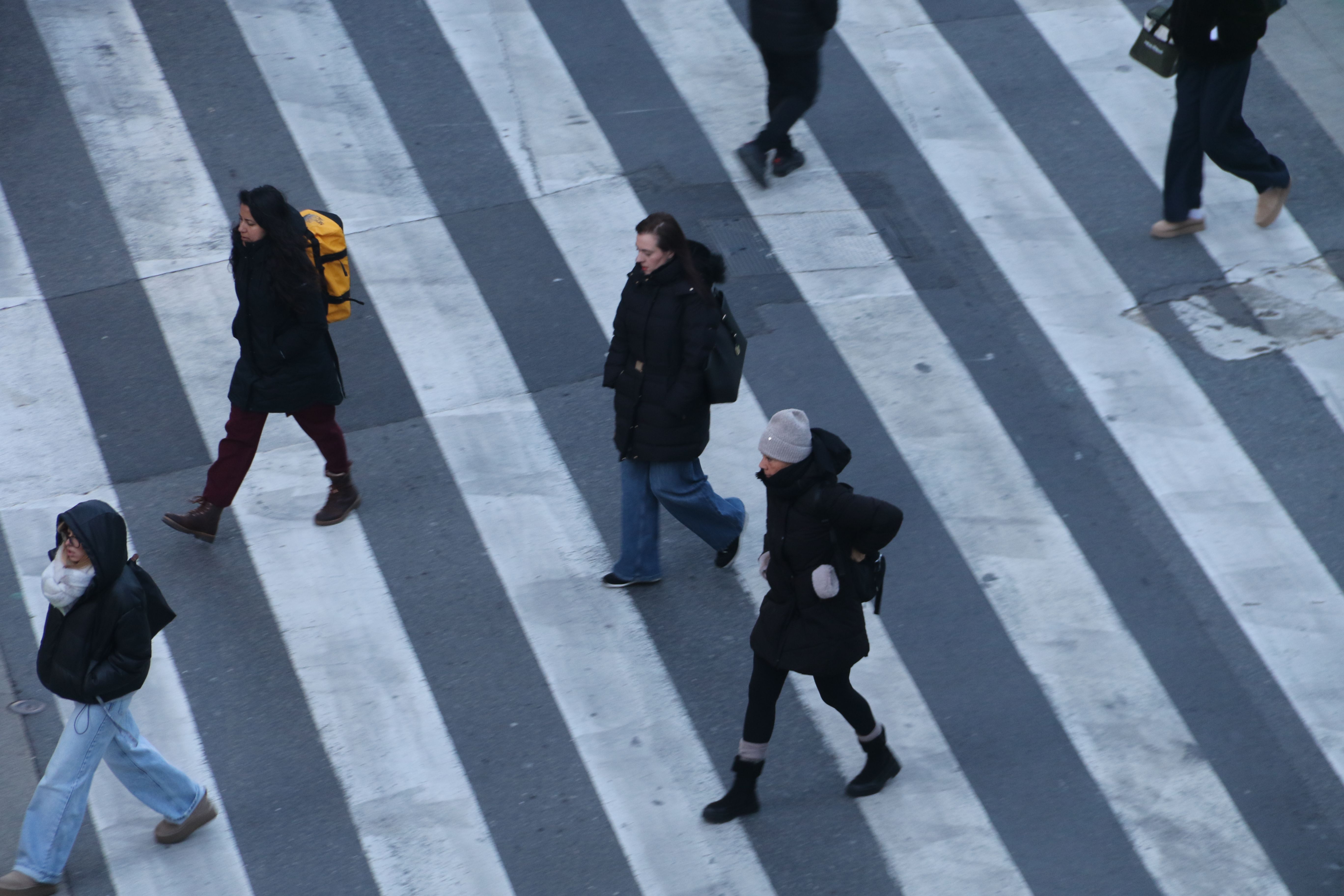Ciutadans ben tapats creuant un pas de vianants aquest matí de dimecres a Andorra la Vella.