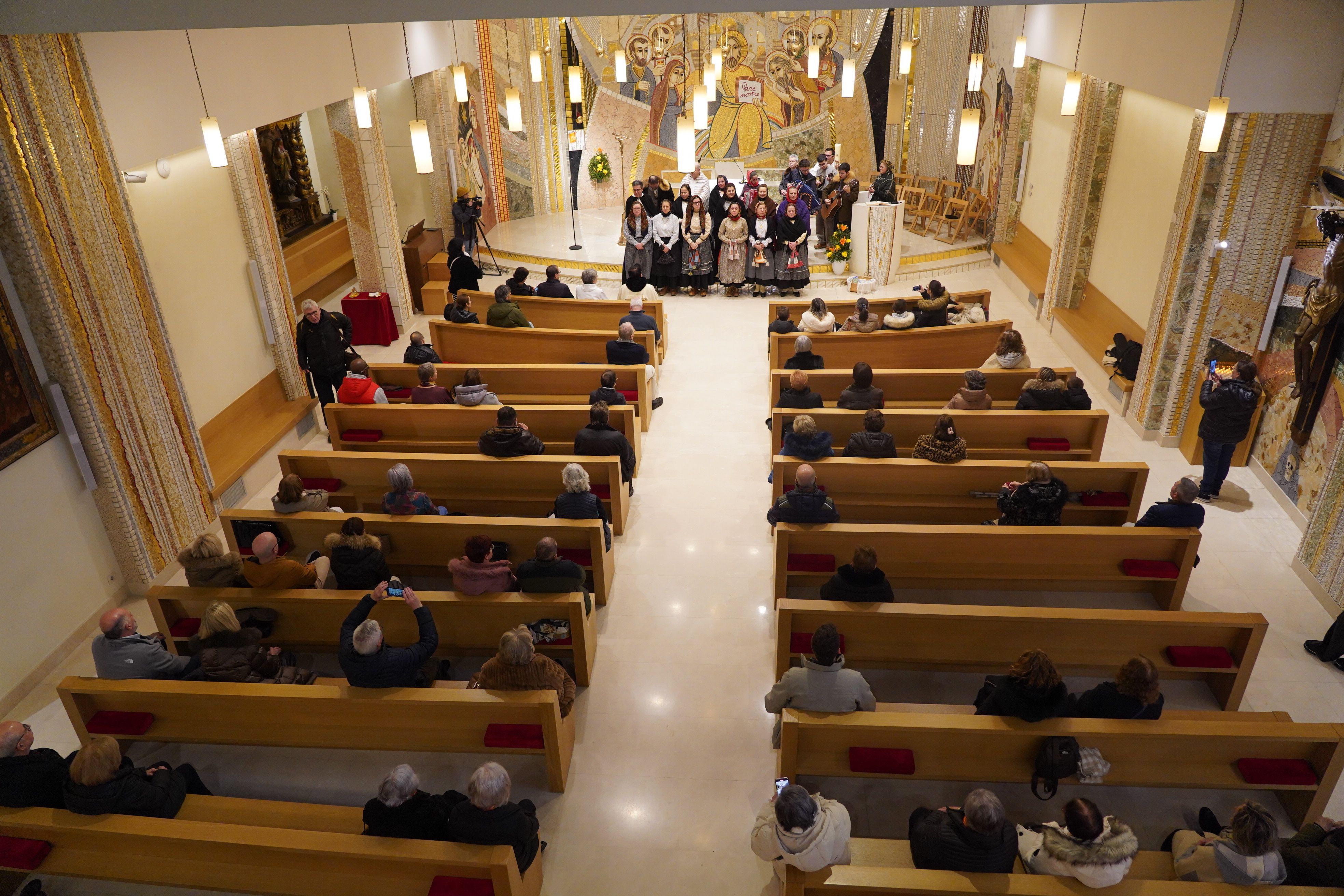 Els assistents a l'ofici seguint l'actuació. 