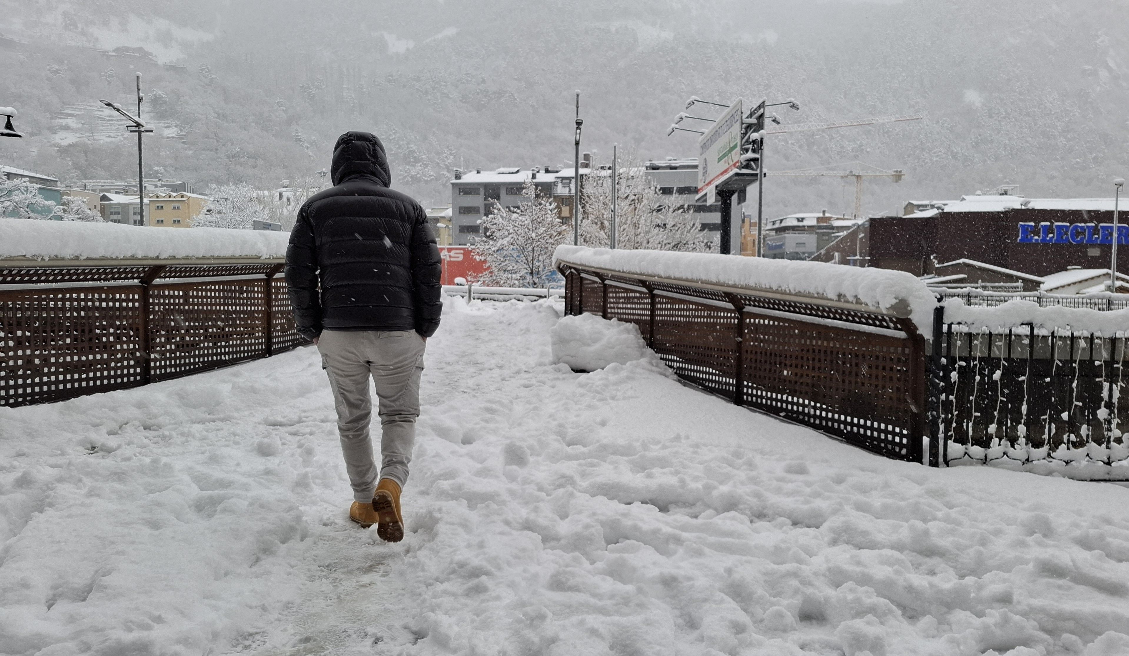 Una persona caminant per la neu el dia de la nevada a la capital.