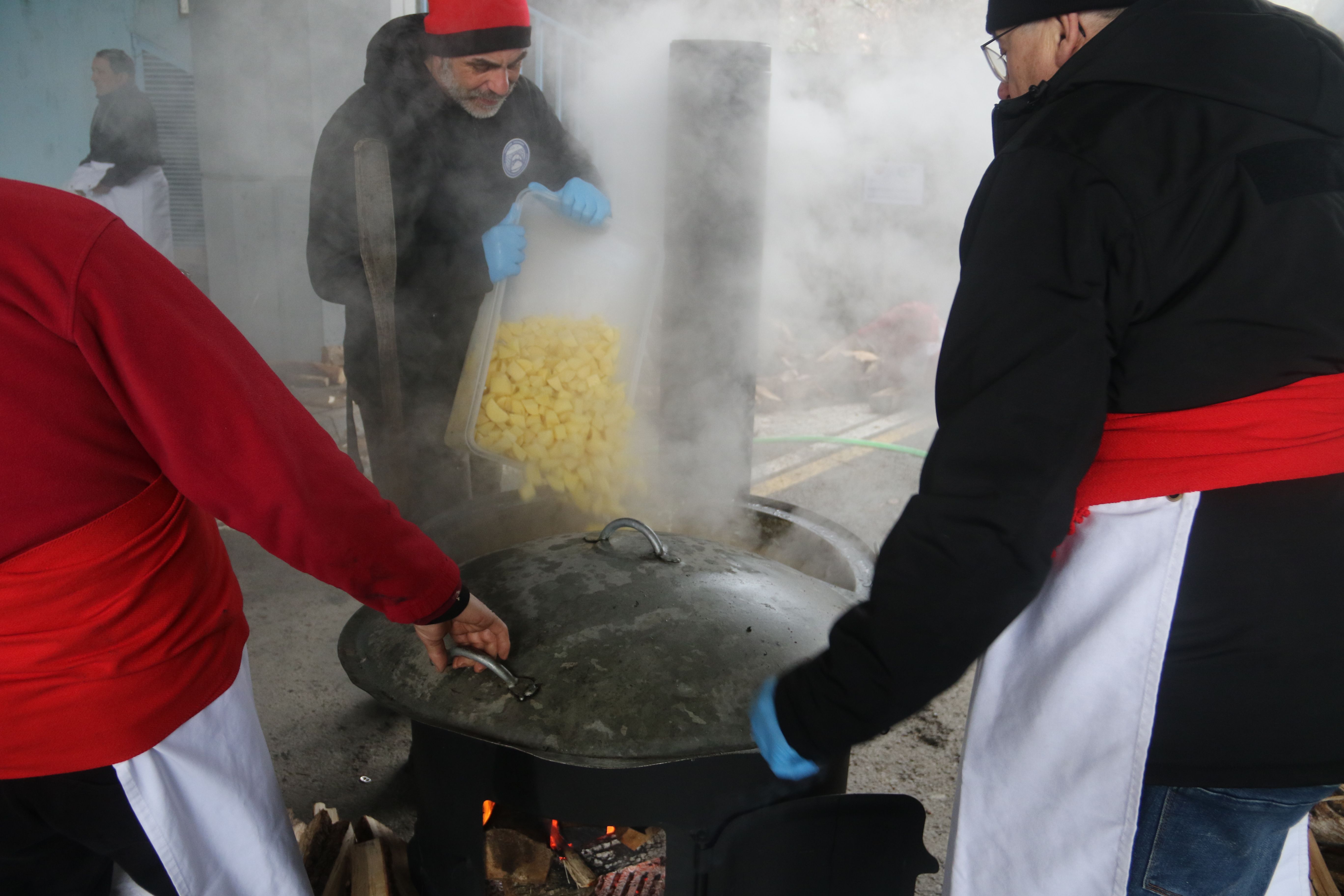 Els esudellaires afegint patata al caldo.