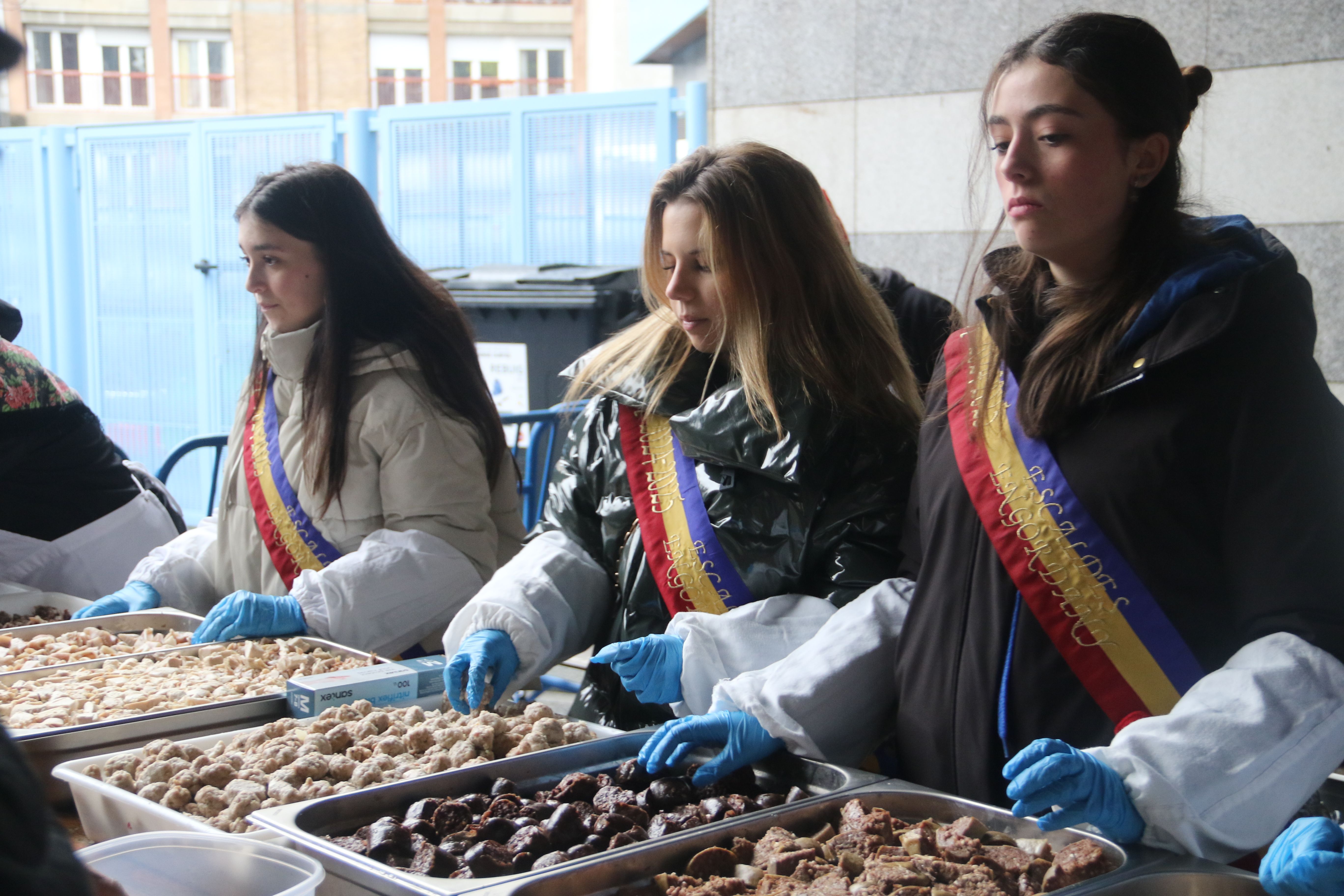 Els representants del pubillatge distribuïnt la carn d'olla. 