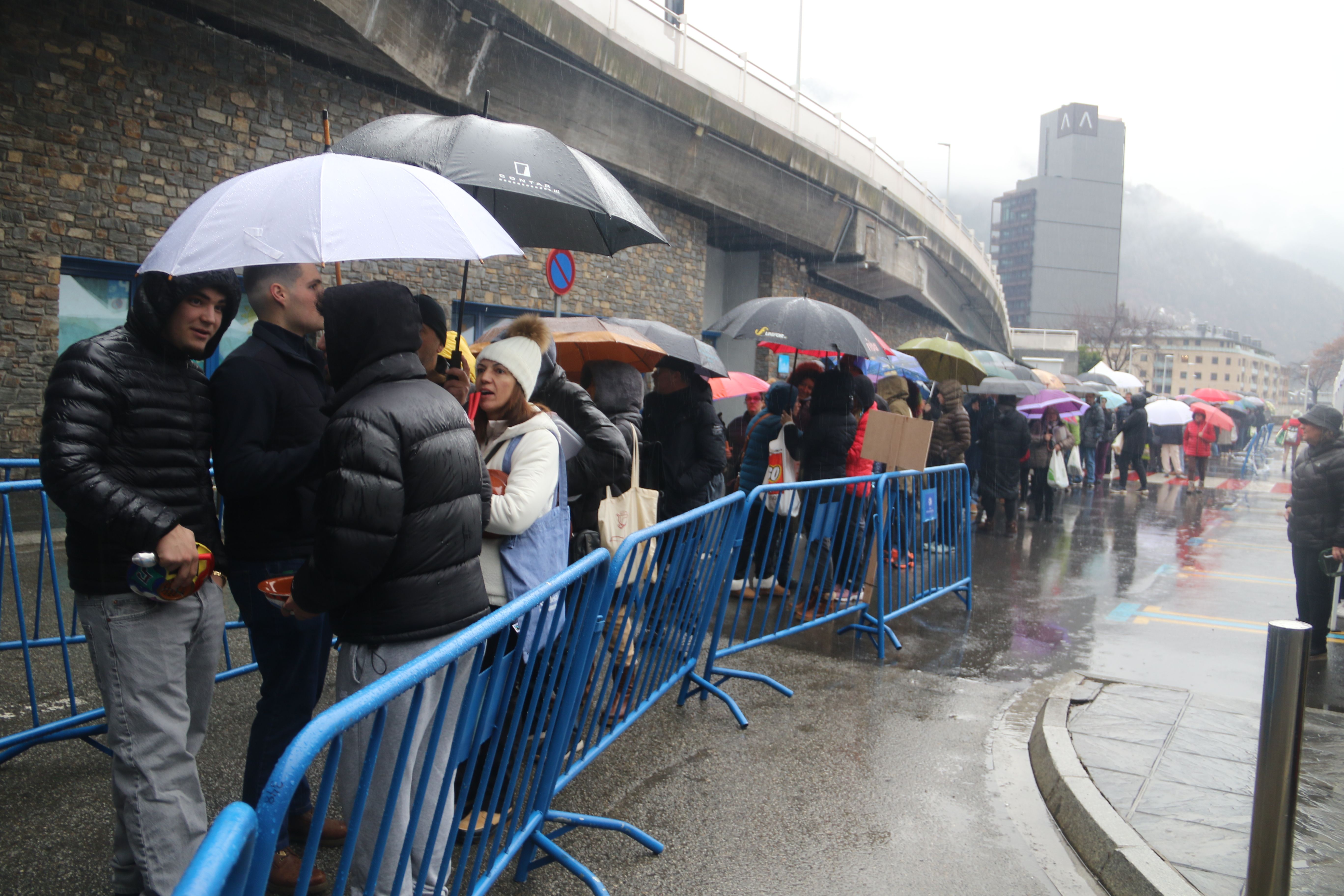 La cua ja sota la pluja.