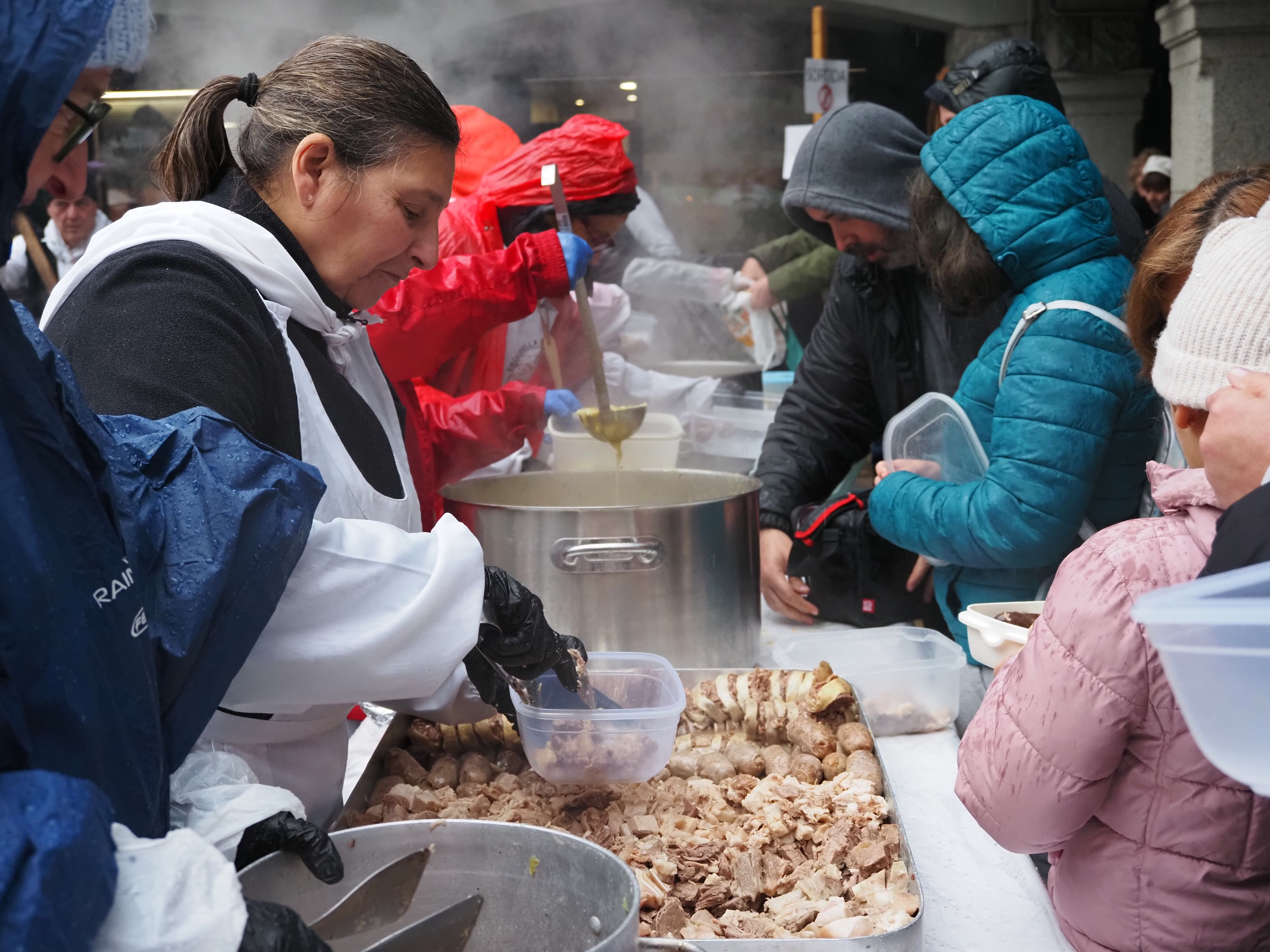 Repartiment de l'escudella sota la pluja.
