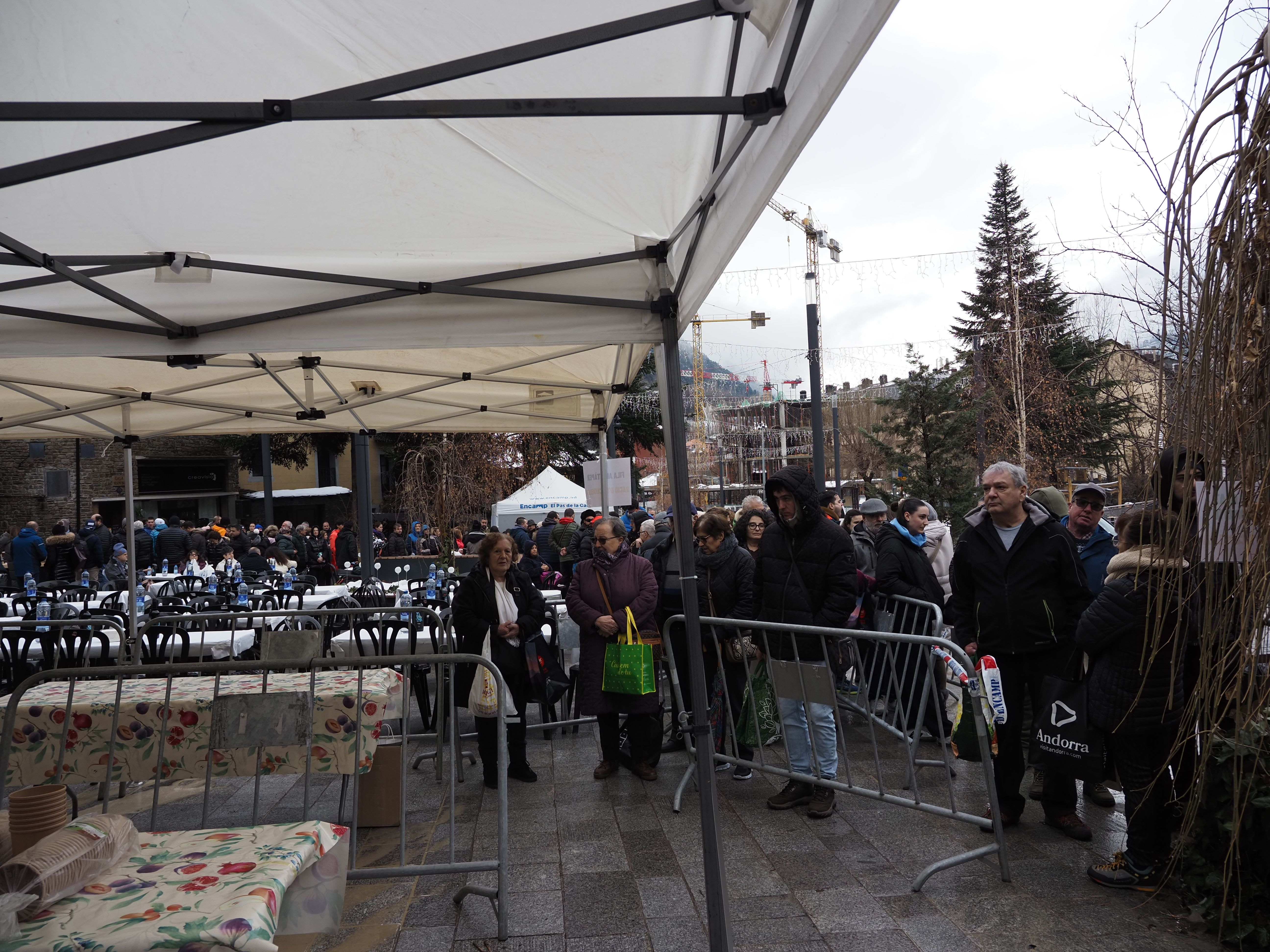 Ciutadans fent cua abans del repartiment de l'escudella.