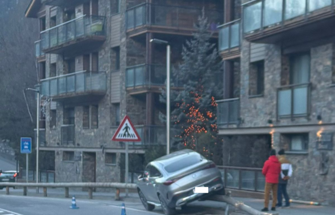 El cotxe ha quedat sobre la barana protectora de la carretera.