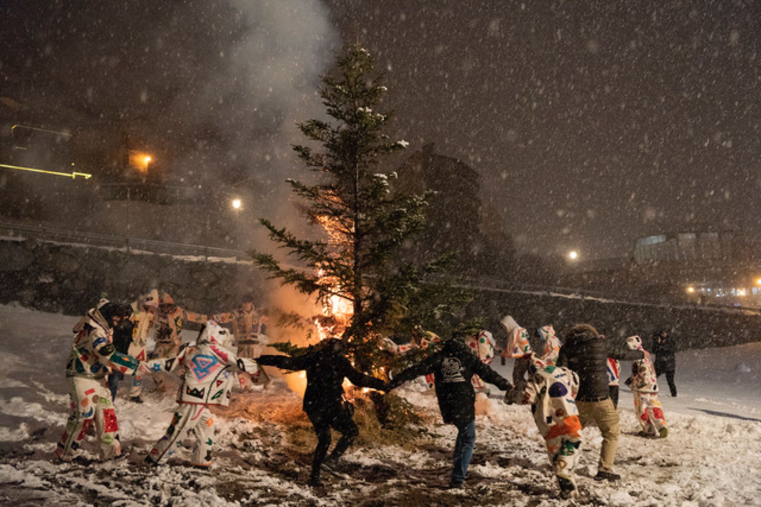 Els arlequins de Canillo ballant al tomb de l'arbre que no ha cremat gaire bé.
