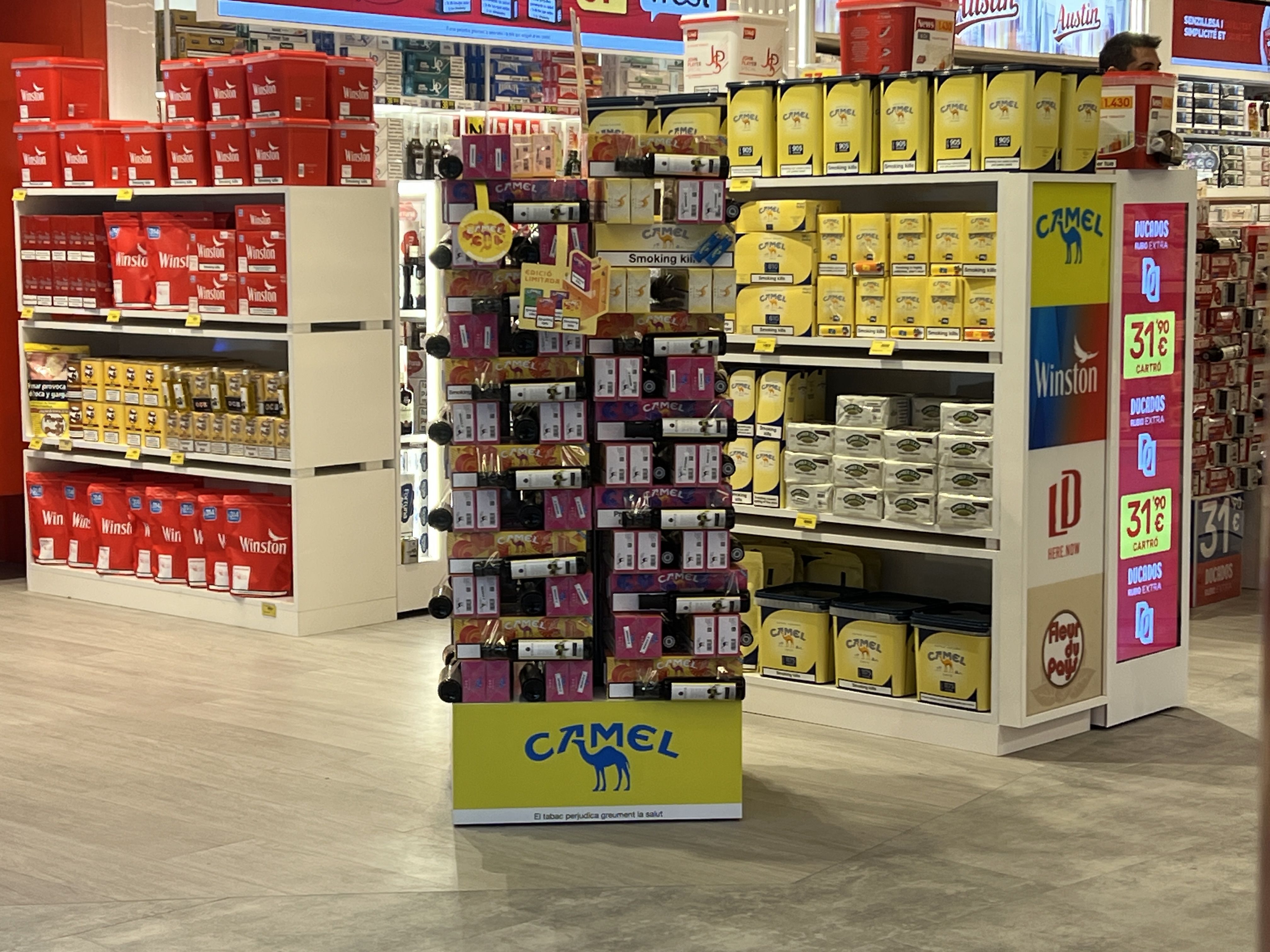 Lineals de productes de tabac en una superfície comercial.