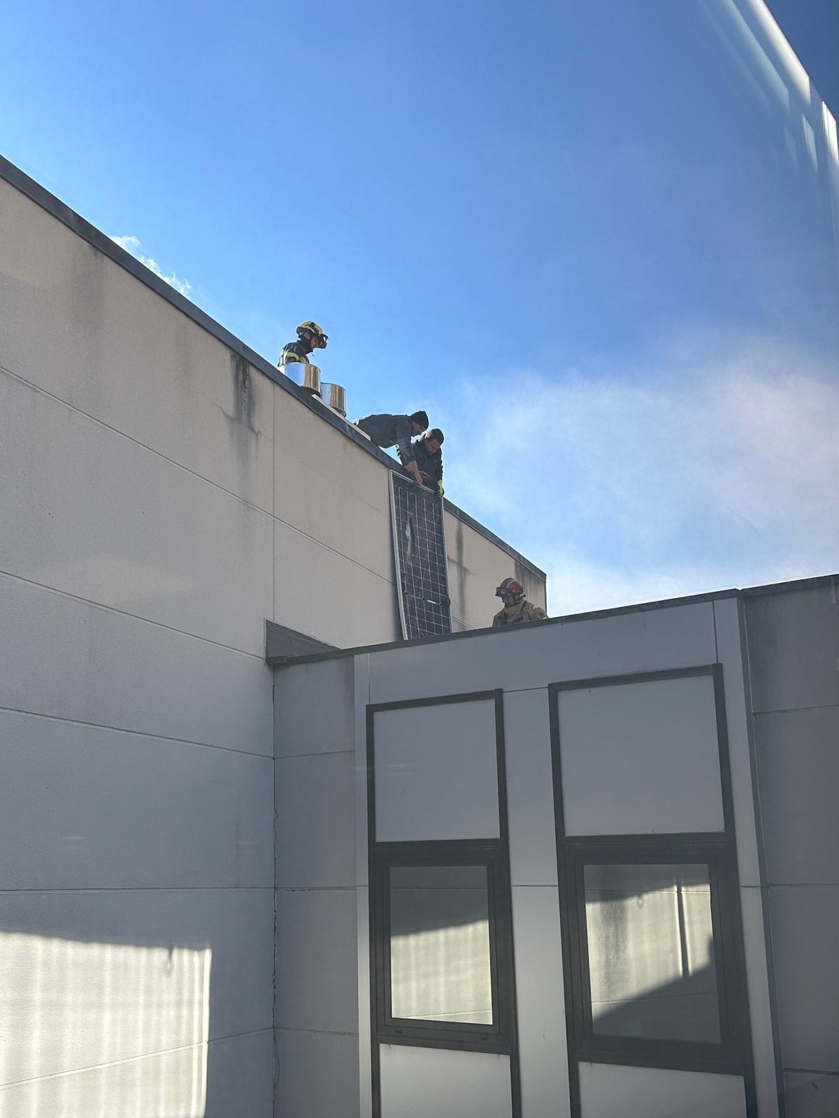 Instal·ladors i Bombers intervenint en el despreniment de les plaques solars.