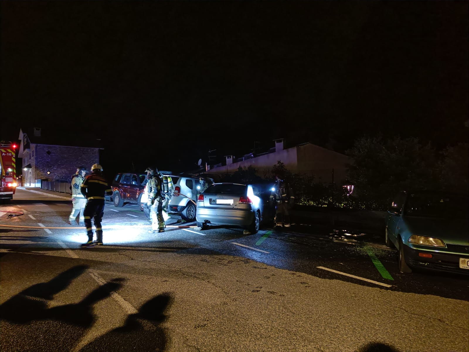 Els bombers acabant d'apagar els cotxes.