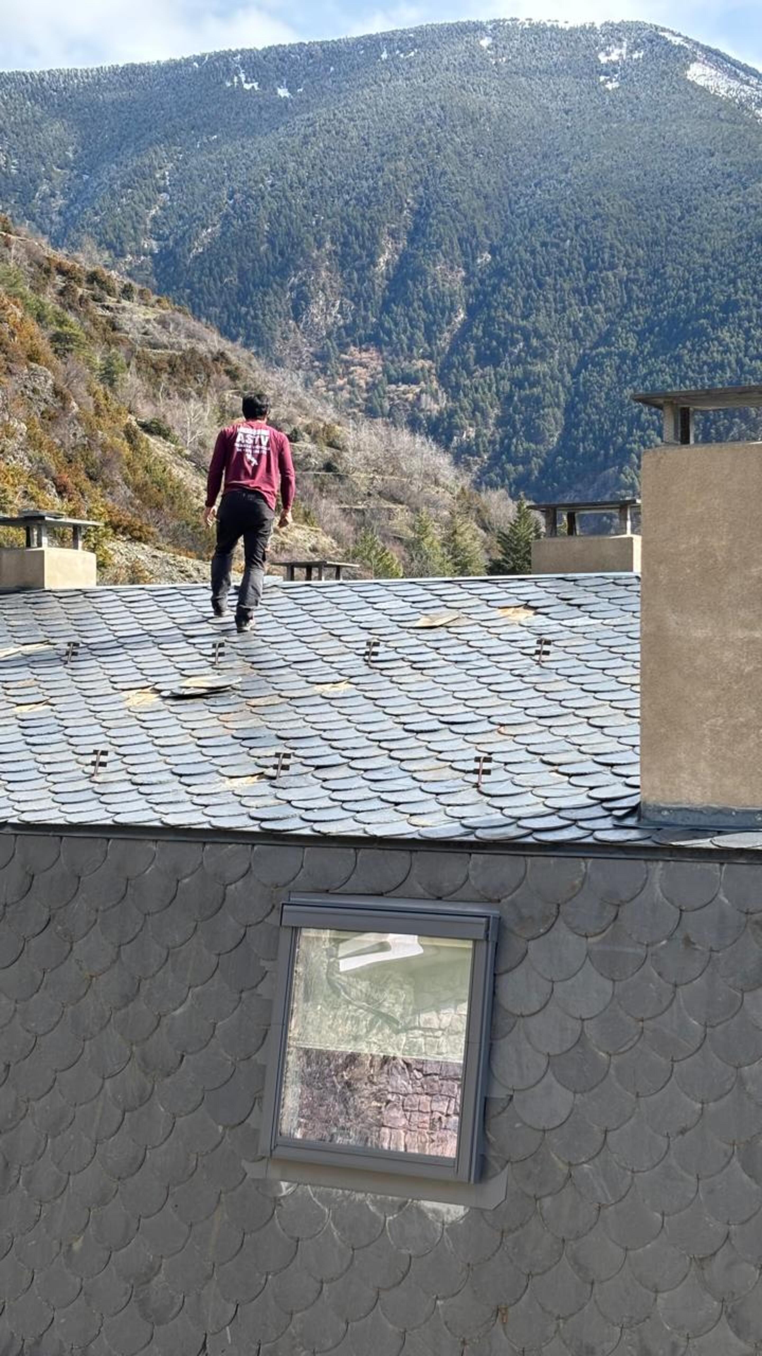 L'operari caminant per la teulada sense cap mesura de protecció.