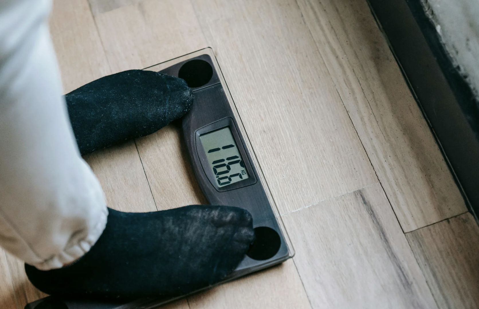 Un home es pesa en una bàscula.