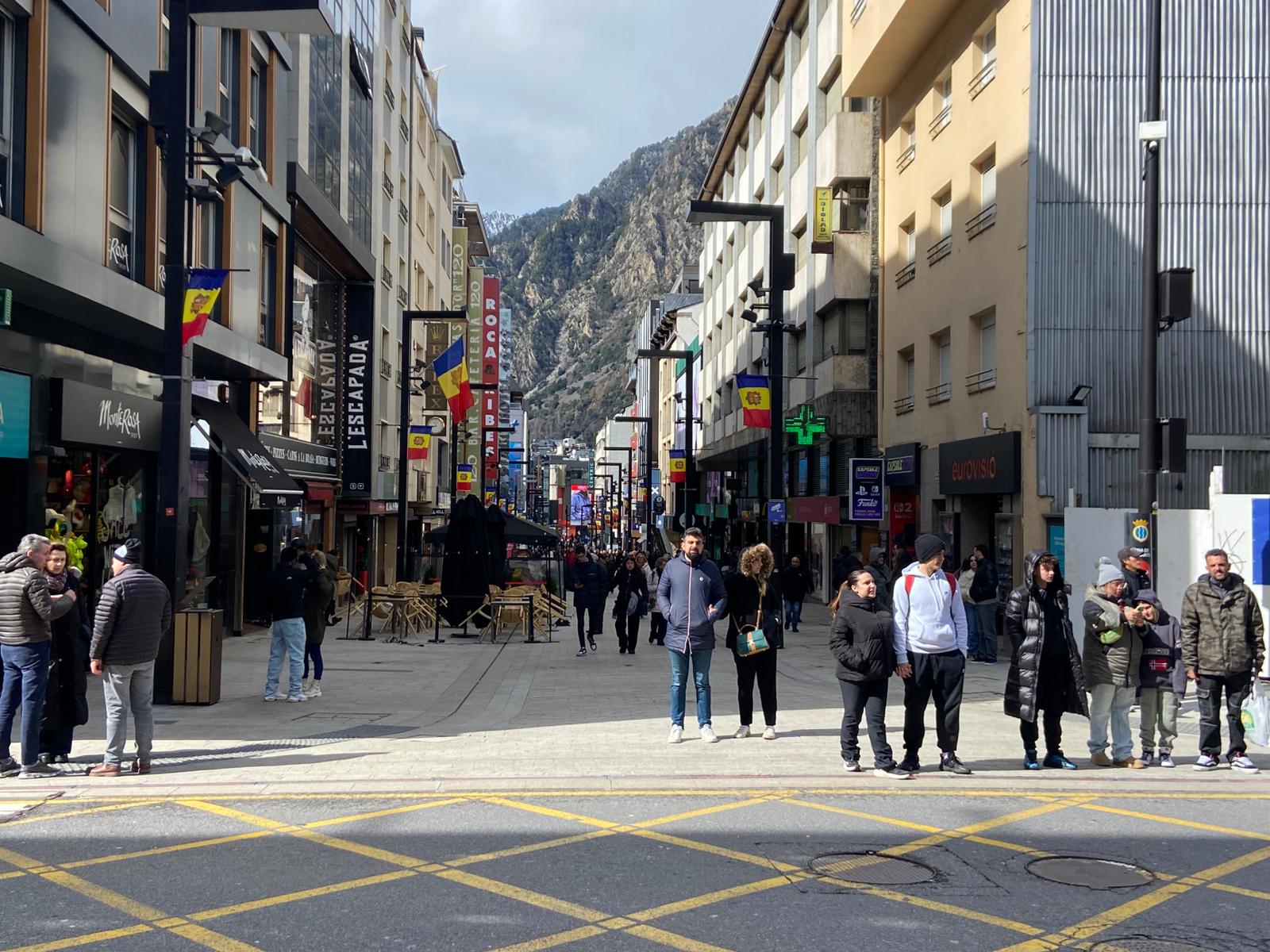 Diversos turistes i residents, passejant per la zona comercial, a l'alçada del carrer de la Unió.