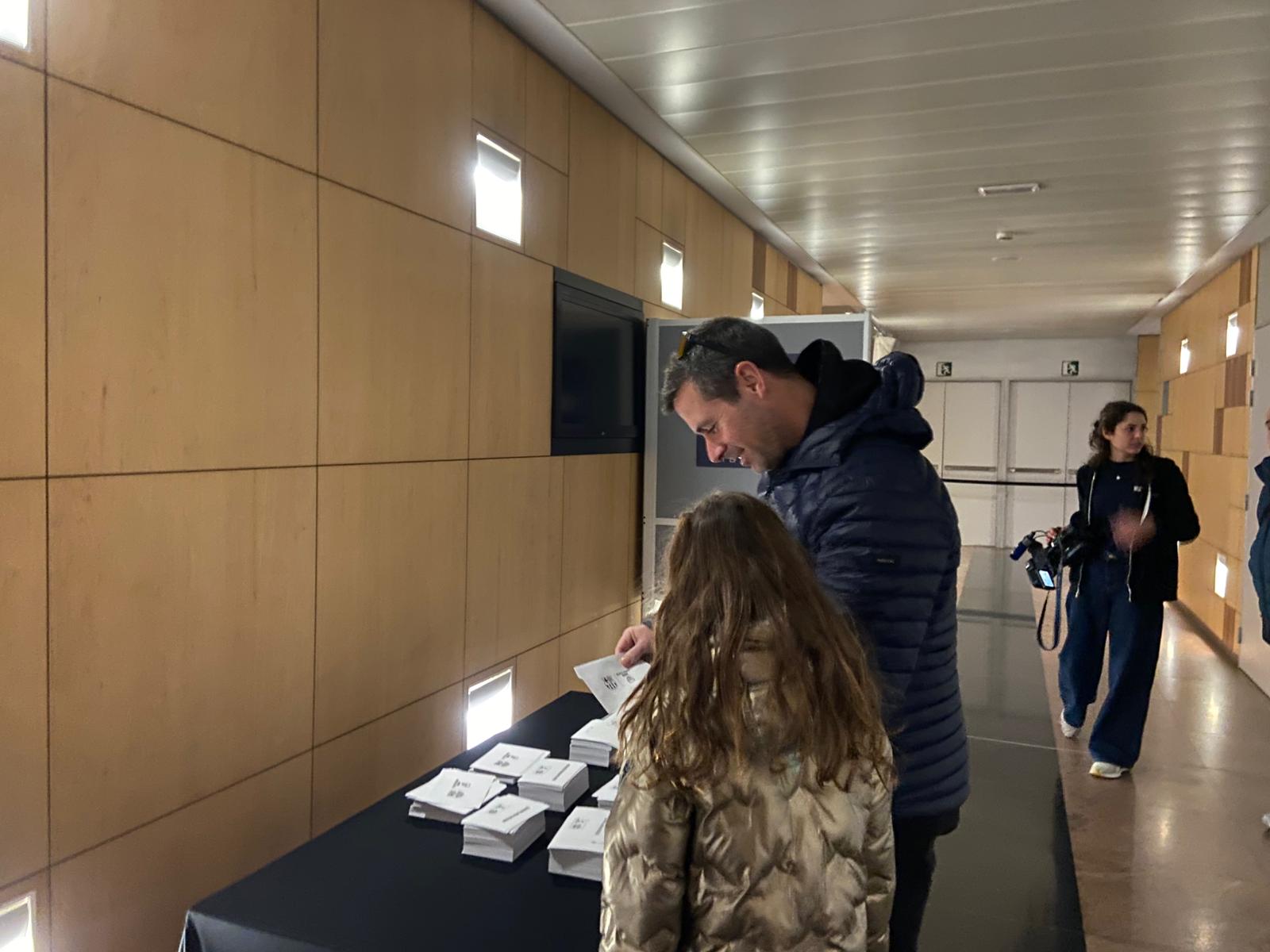 Pare i filla, agafant el vot abans d'entrar. Pare i filla, agafant el vot abans d'entrar.