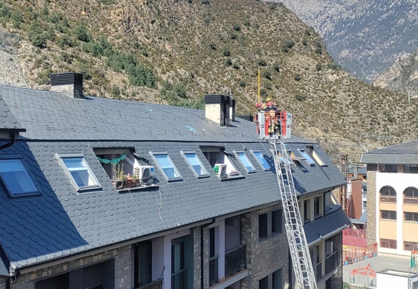 Servei de Bombers en un teulat de Sant Julià per retirar vidres trencats.